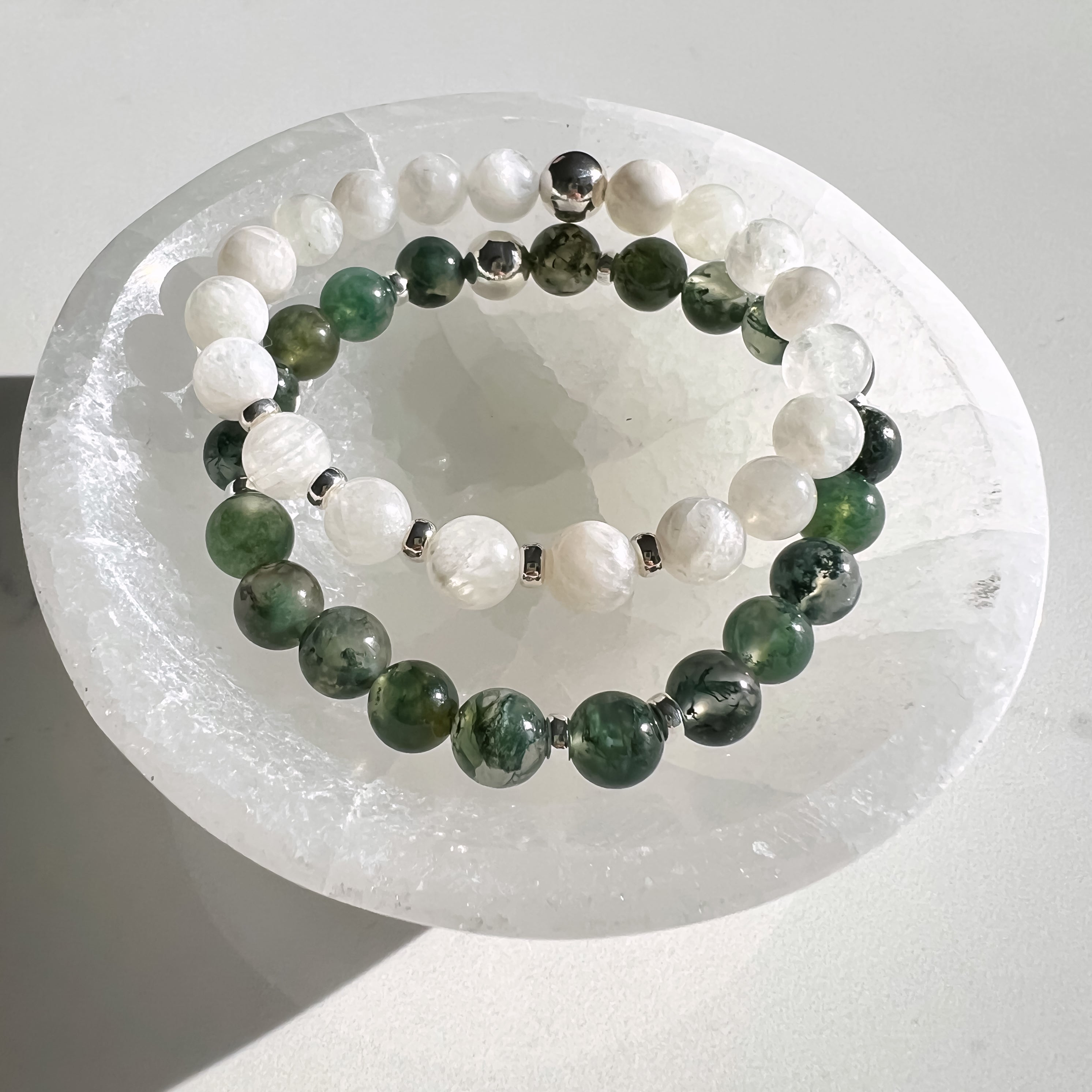 A selenite bowl with crystal bracelets in it