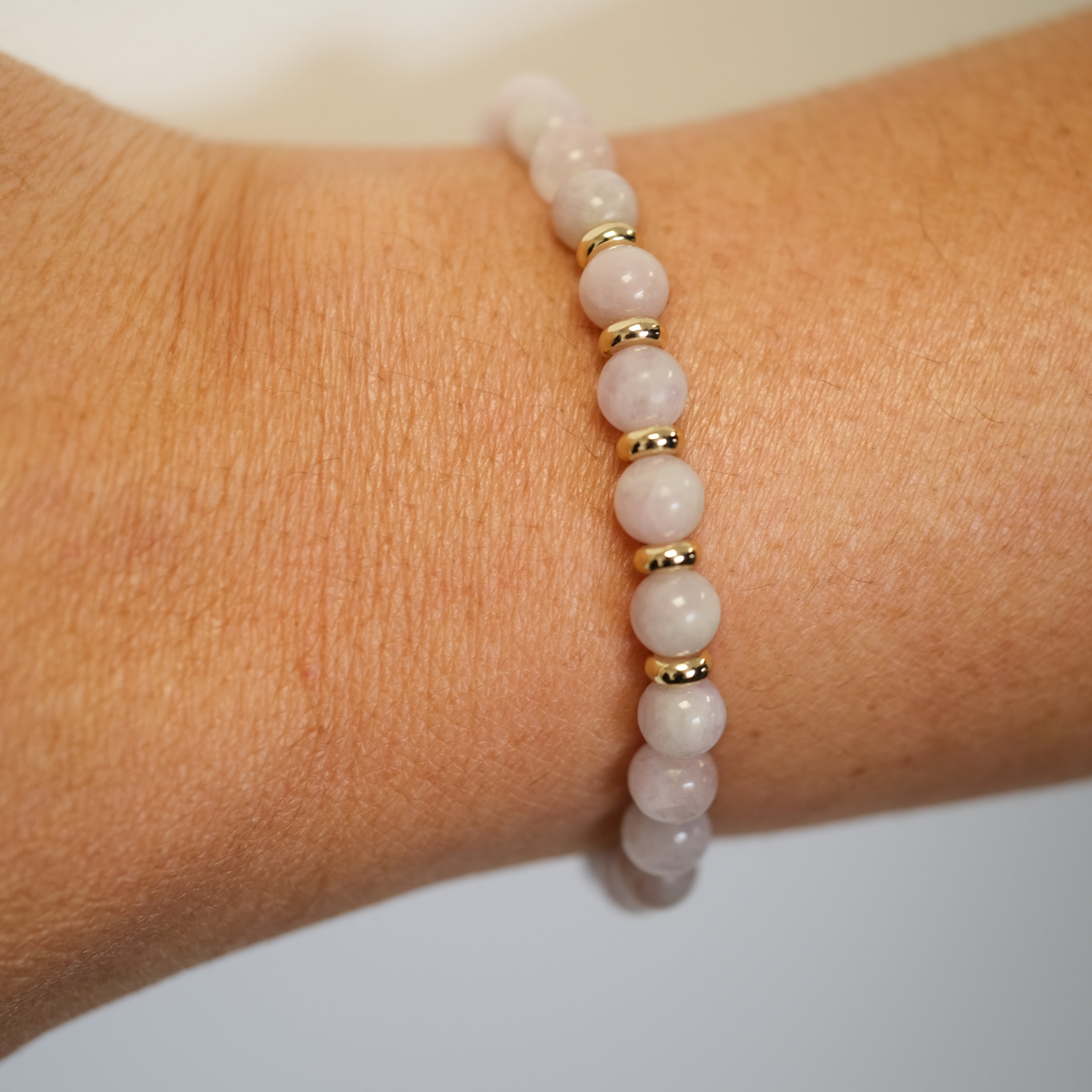 A 6mm Kunzite bracelet in 6mm beads worn on a model's wrist