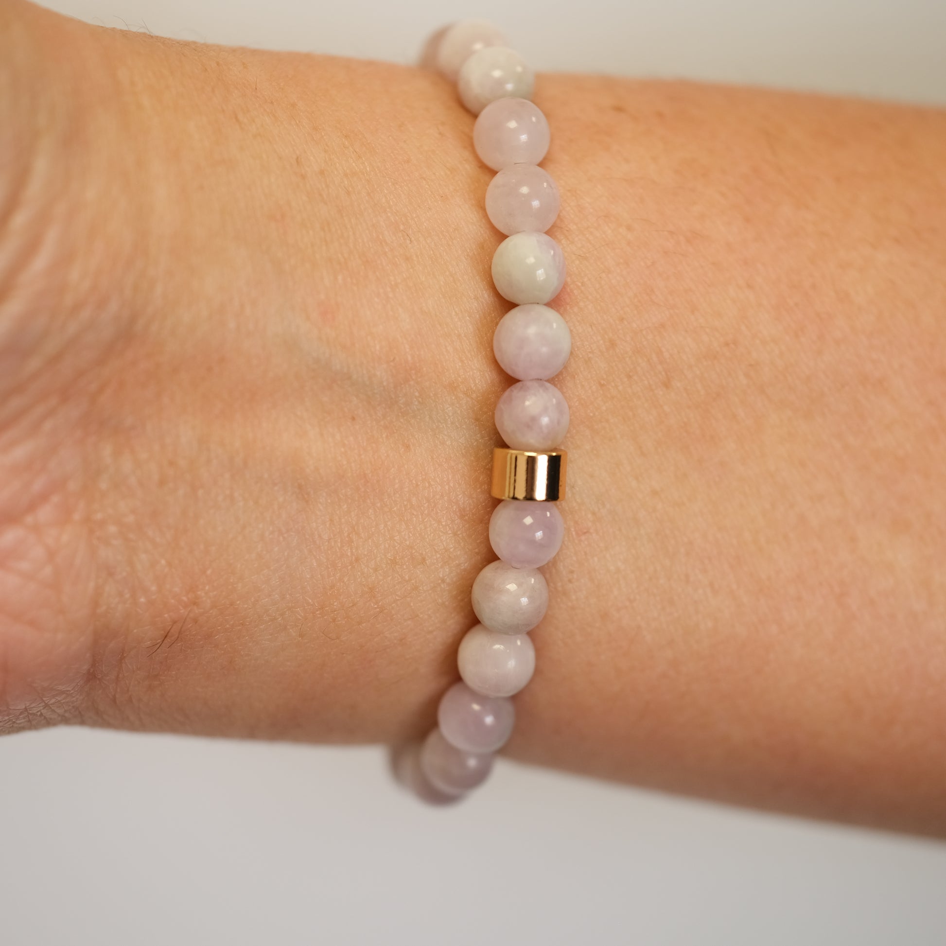 A 6mm Kunzite bracelet in 6mm beads worn on a model's wrist from behind