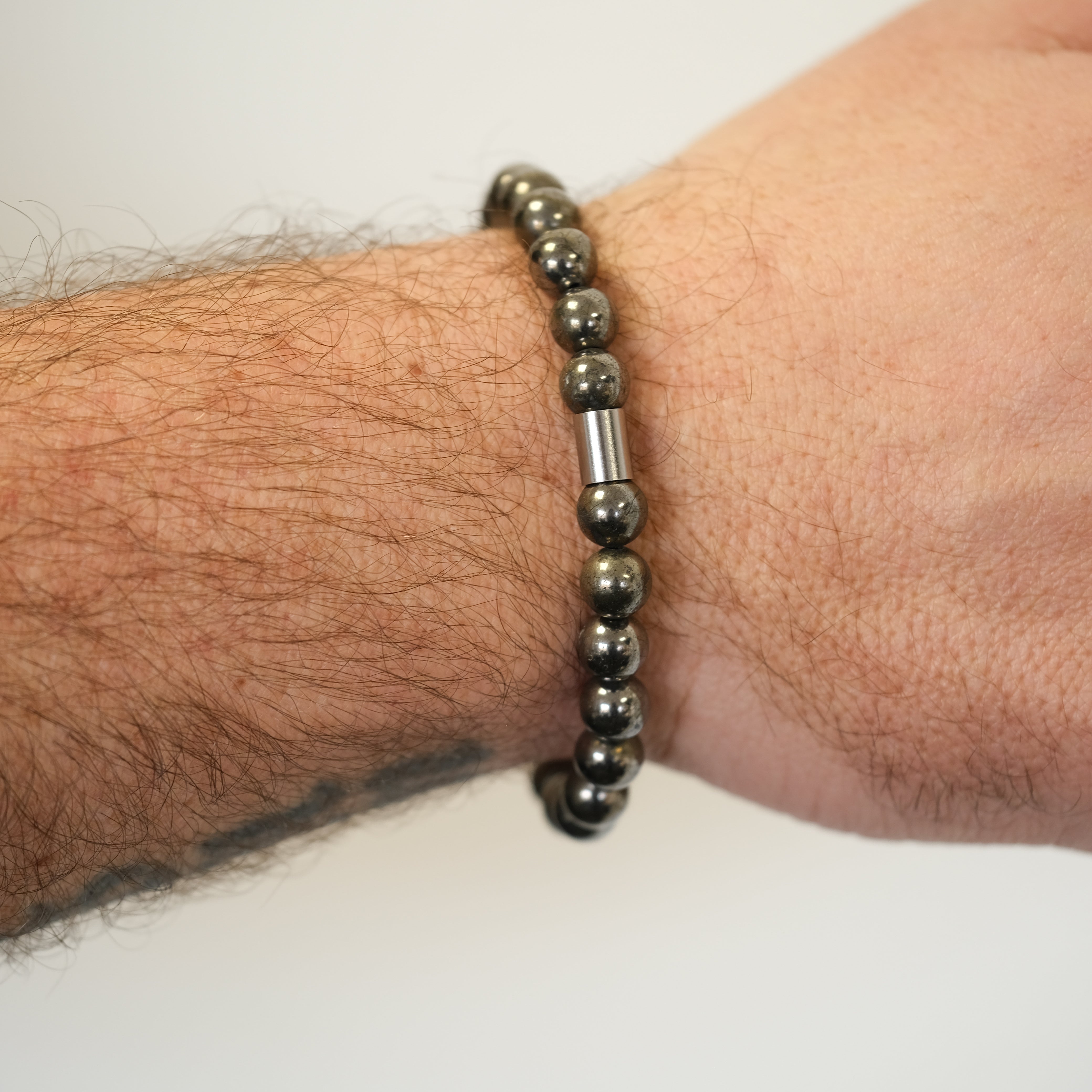 A pyrite bracelet worn on a model's wrist from behind 