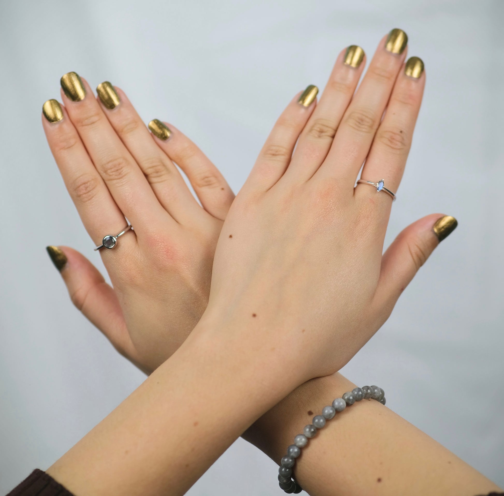 A model wearing labradorite gemstone rings and a bracelet