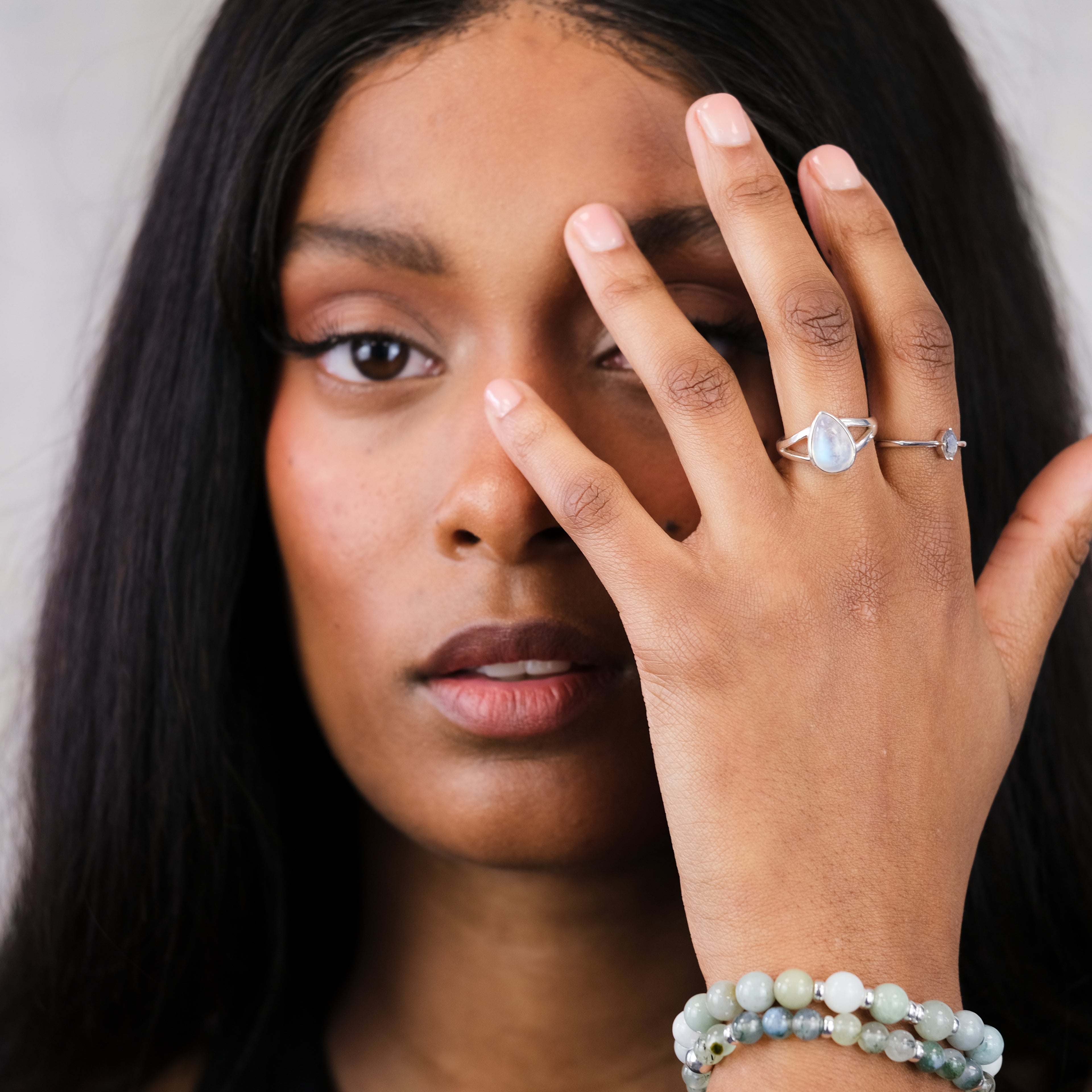 A model wearing Samayla Jewellery's rainbow moonstone teardrop ring and Labradorite minimal marquis ring