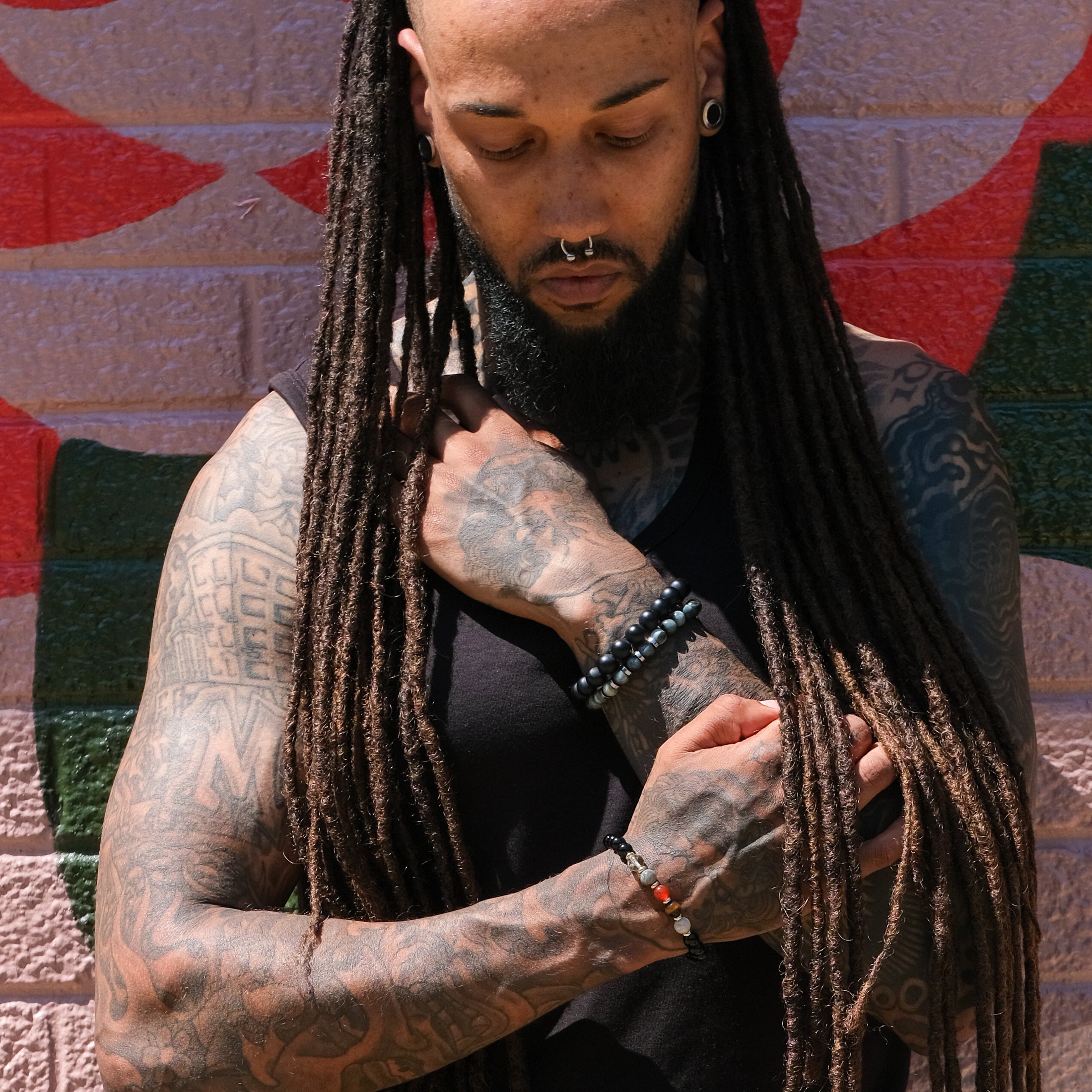 A model wearing three crystal bracelets. A matte onyx, eagle eye and Leo zodiac.