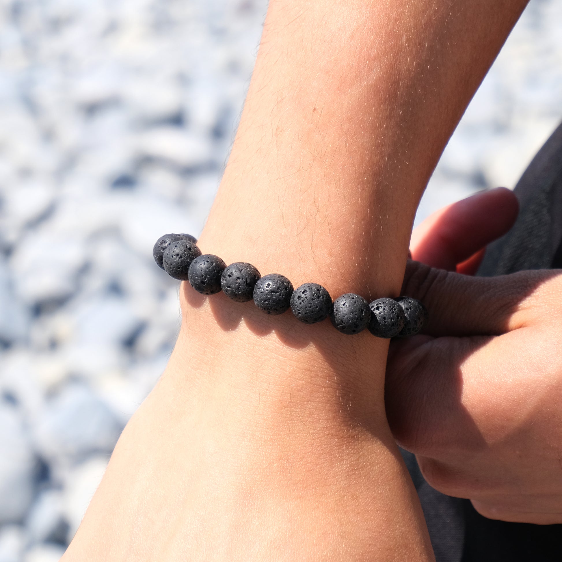 A model wearing A 10mm lava stone bracelet with steel accessory