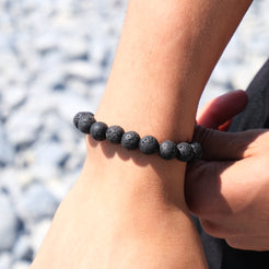 A model wearing A 10mm lava stone bracelet with steel accessory