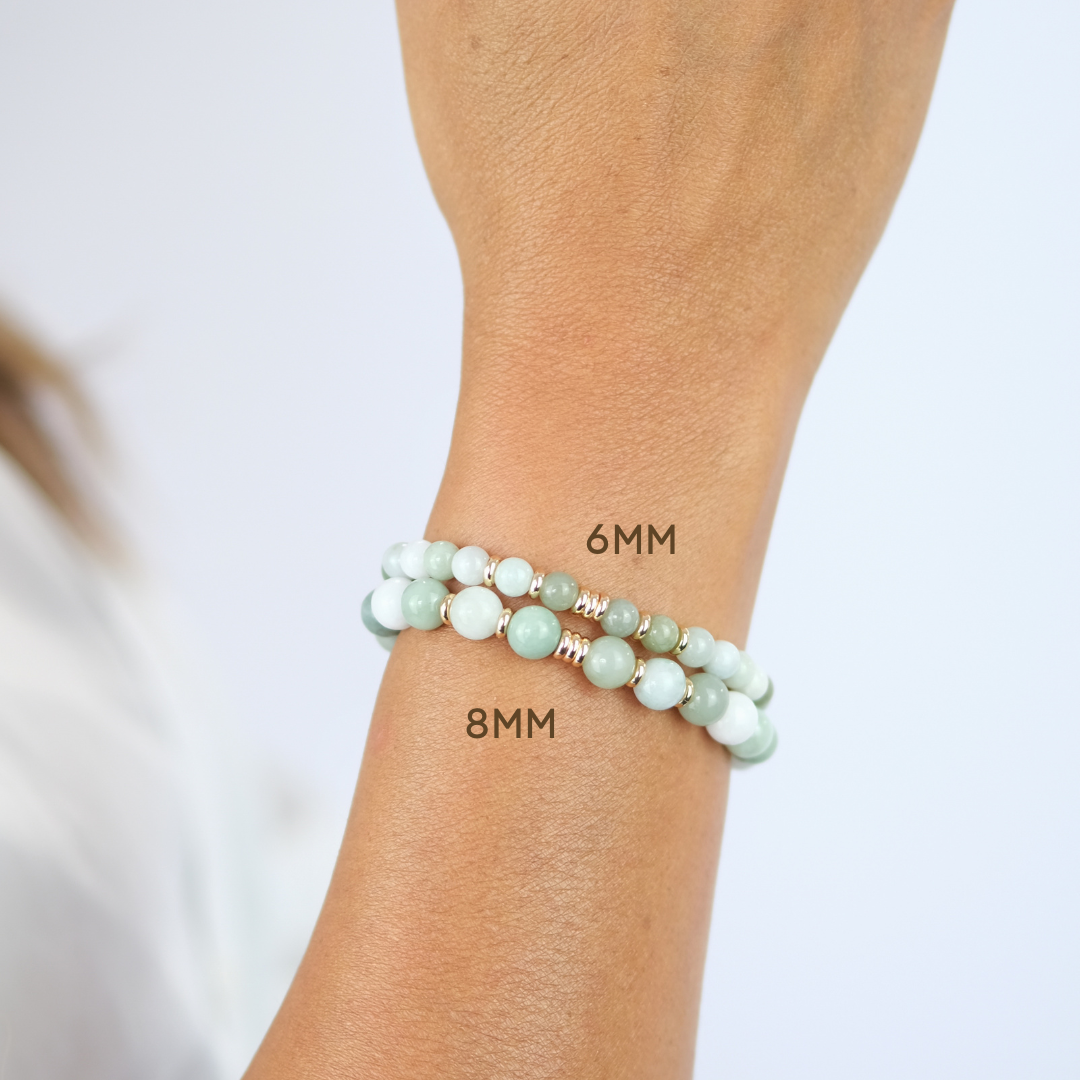 A model wearing A jade gemstone bracelet with gold plated accessories in 6mm and 8mm