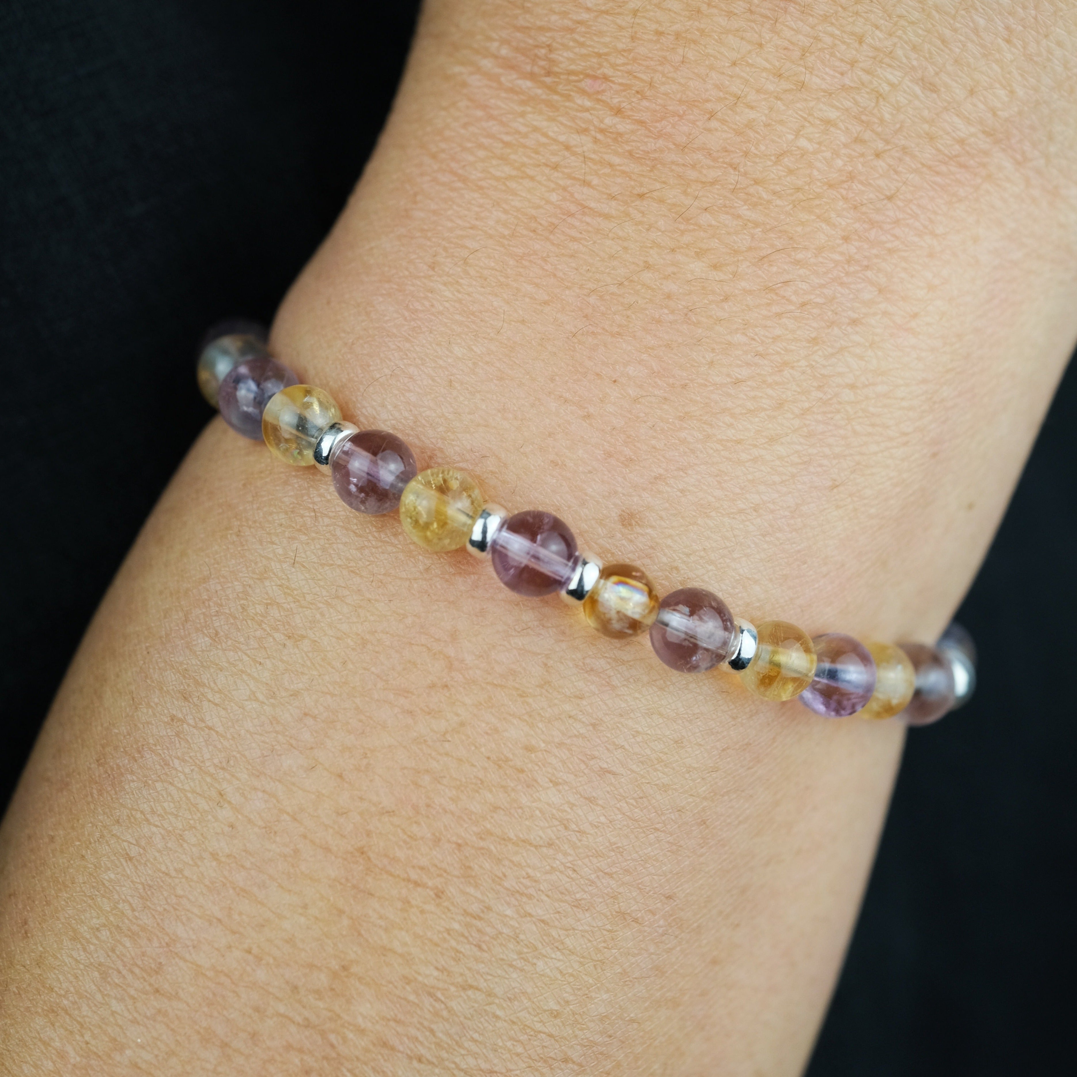 A model wearing an Amethyst and citrine gemstone bracelet with 925 sterling silver accessories