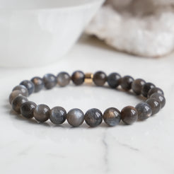 A black moonstone gemstone bracelet with gold feature bead
