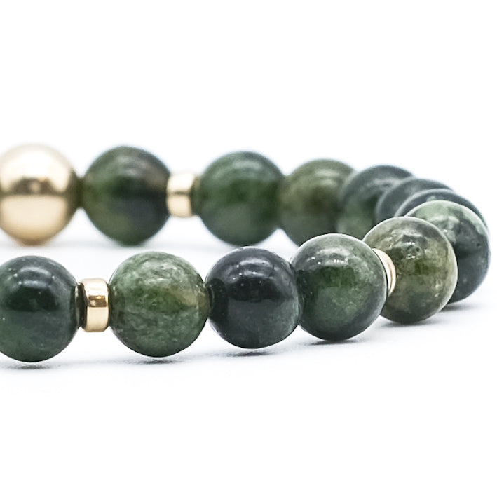 A close up of a Diopside gemstone bracelet with gold filled accessories
