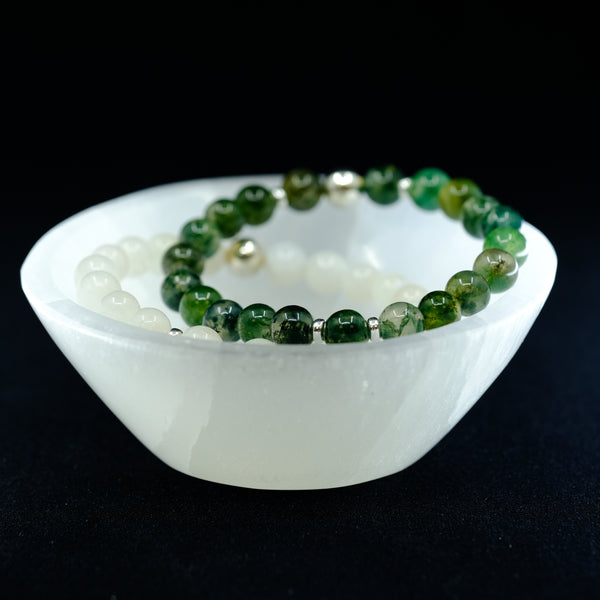 A selenite bowl with crystal bracelets inside it.