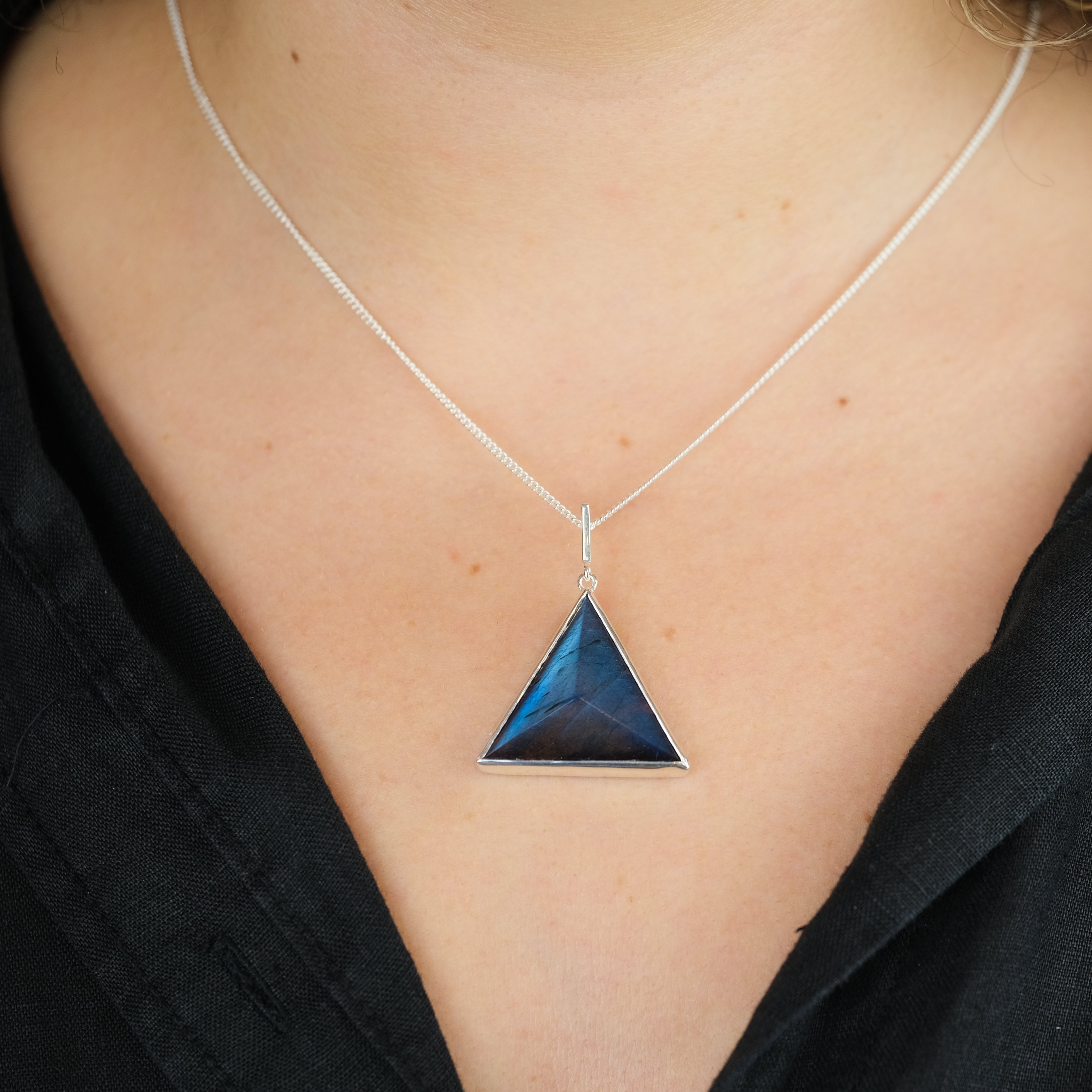 A model wearing a Labradorite triangle pendant necklace with 925 silver chain 