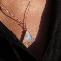A model wearing a triangle rainbow moonstone pendant with 925 silver surround