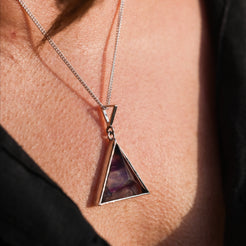 A model wearing a Rainbow Fluorite triangle pendant necklace with 925 silver surround