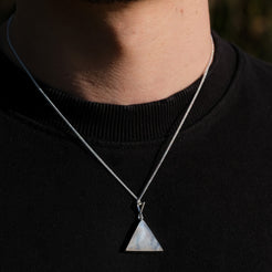 A model wearing a triangle rainbow moonstone pendant with 925 silver surround