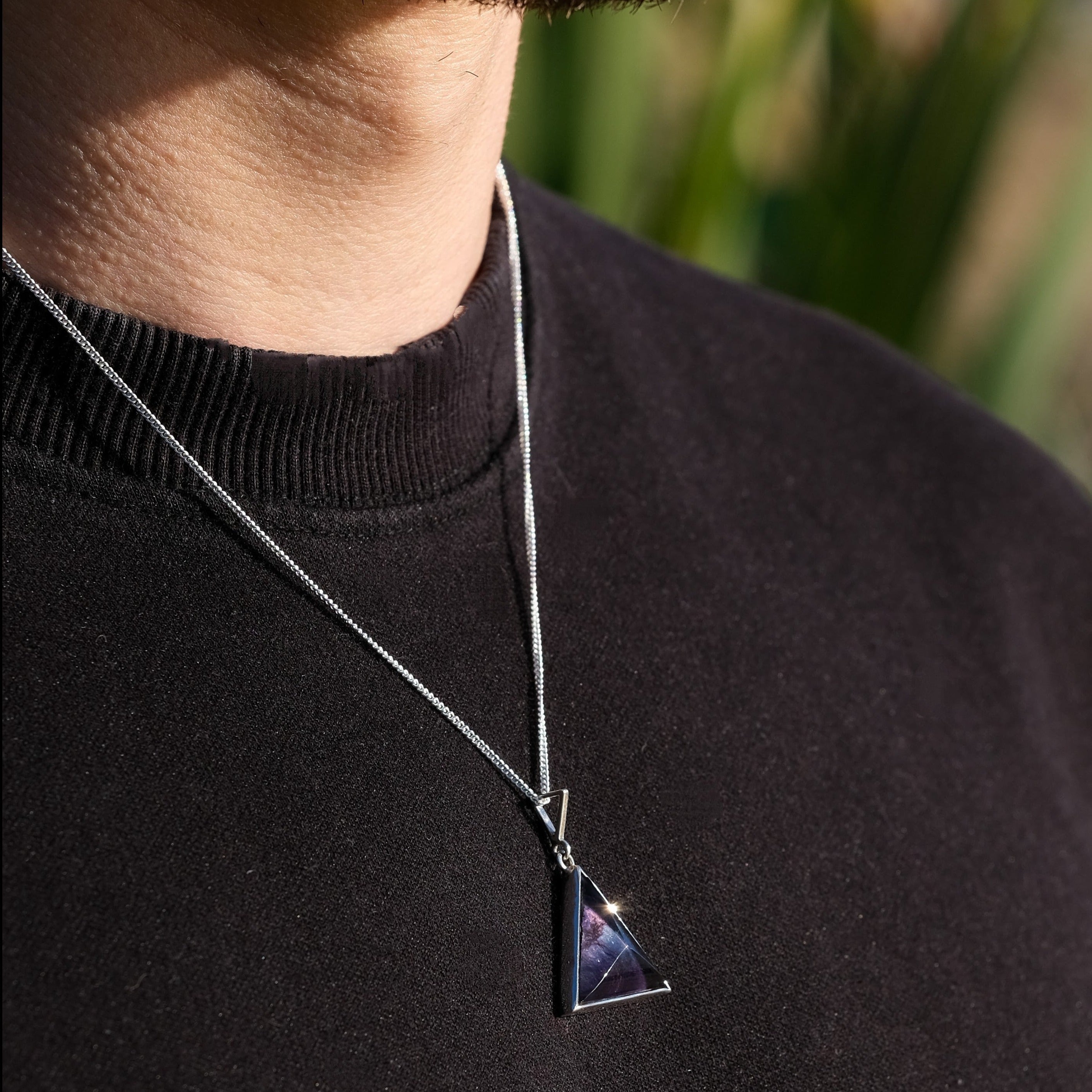 A model wearing a Rainbow Fluorite triangle pendant necklace with 925 silver surround
