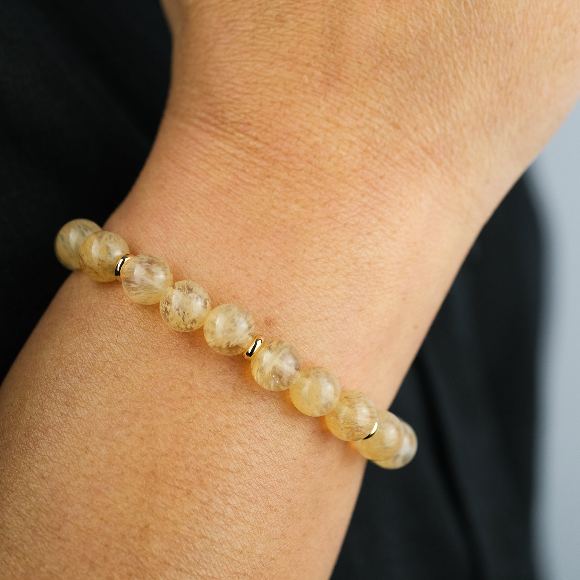 A model wearing a golden healer gemstone bracelet