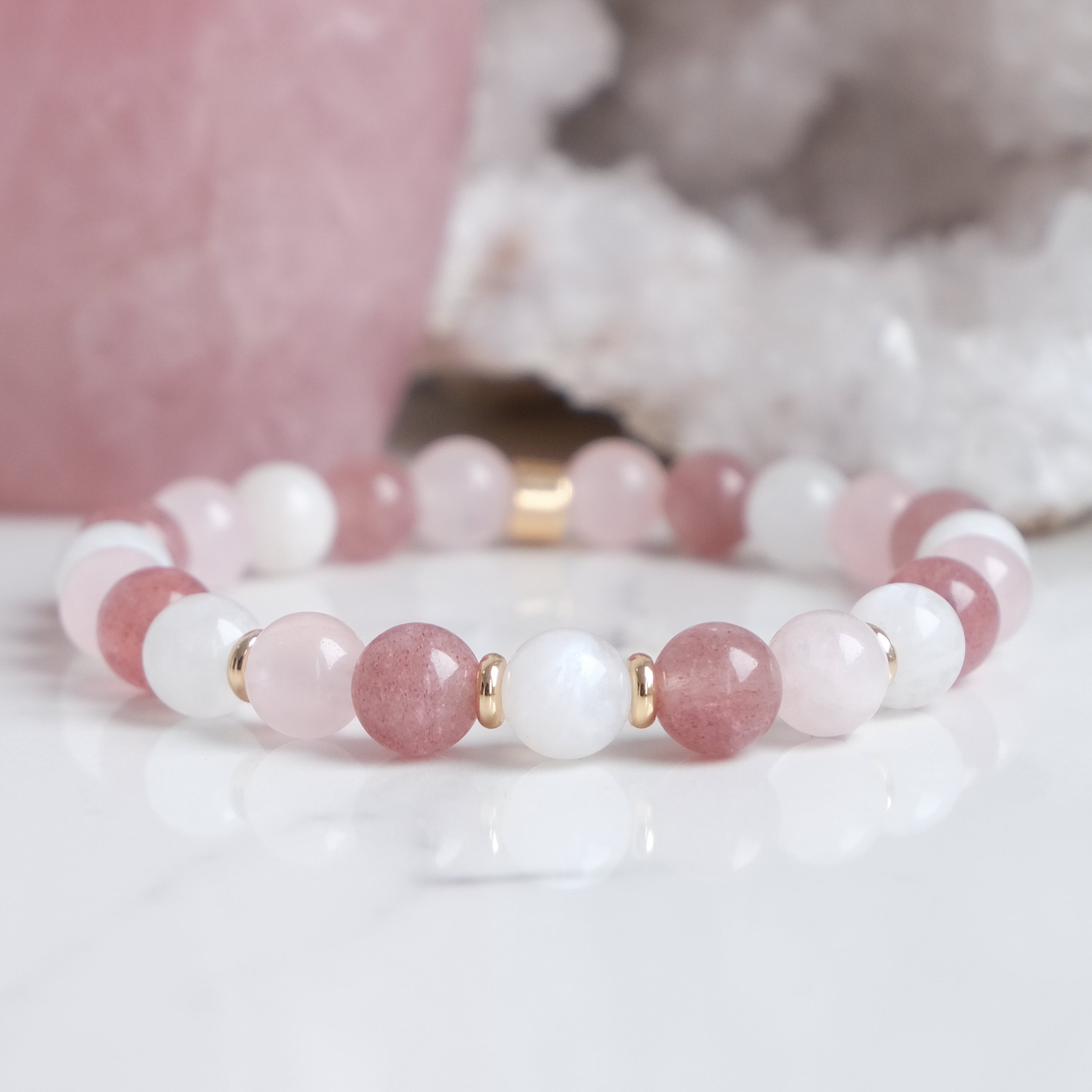 A moonstone, strawberry quartz and rose quartz gemstone bracelet with gold accessories