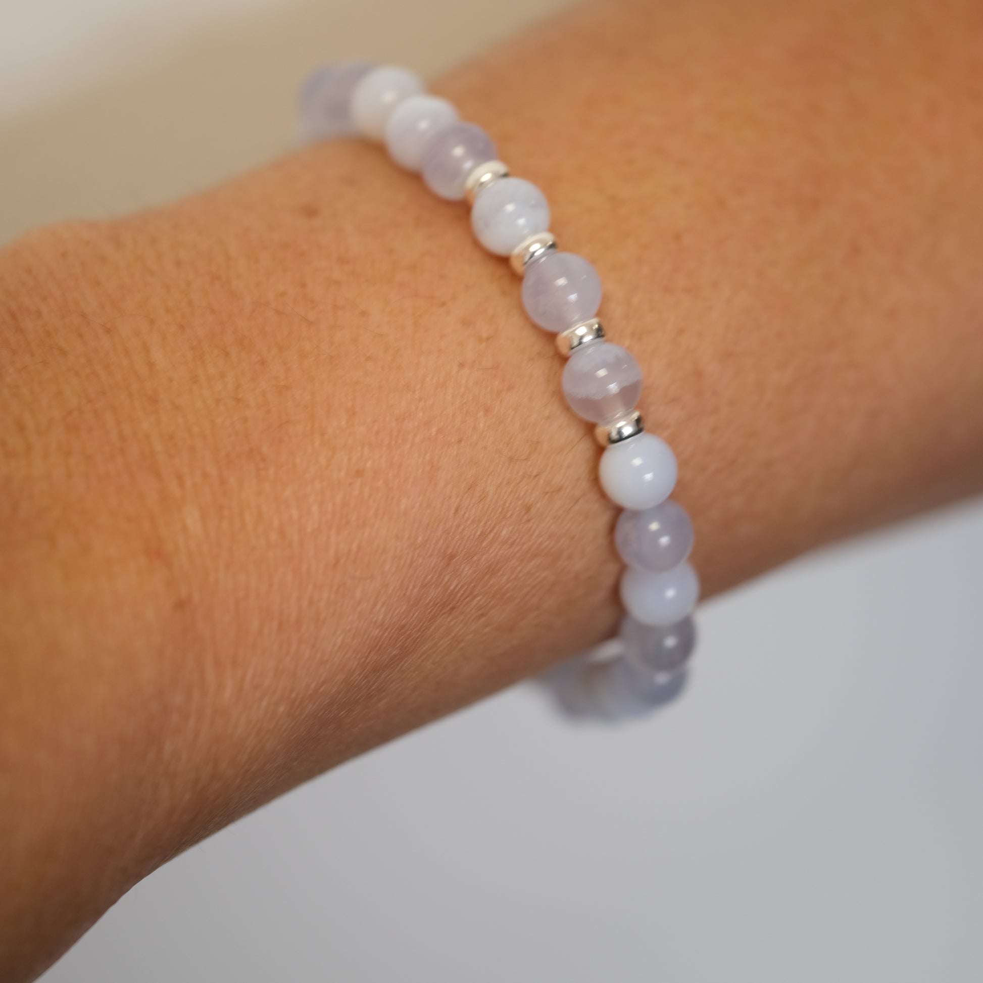 Blue lace agate gemstone bracelet in 6mm beads worn on a model's wrist