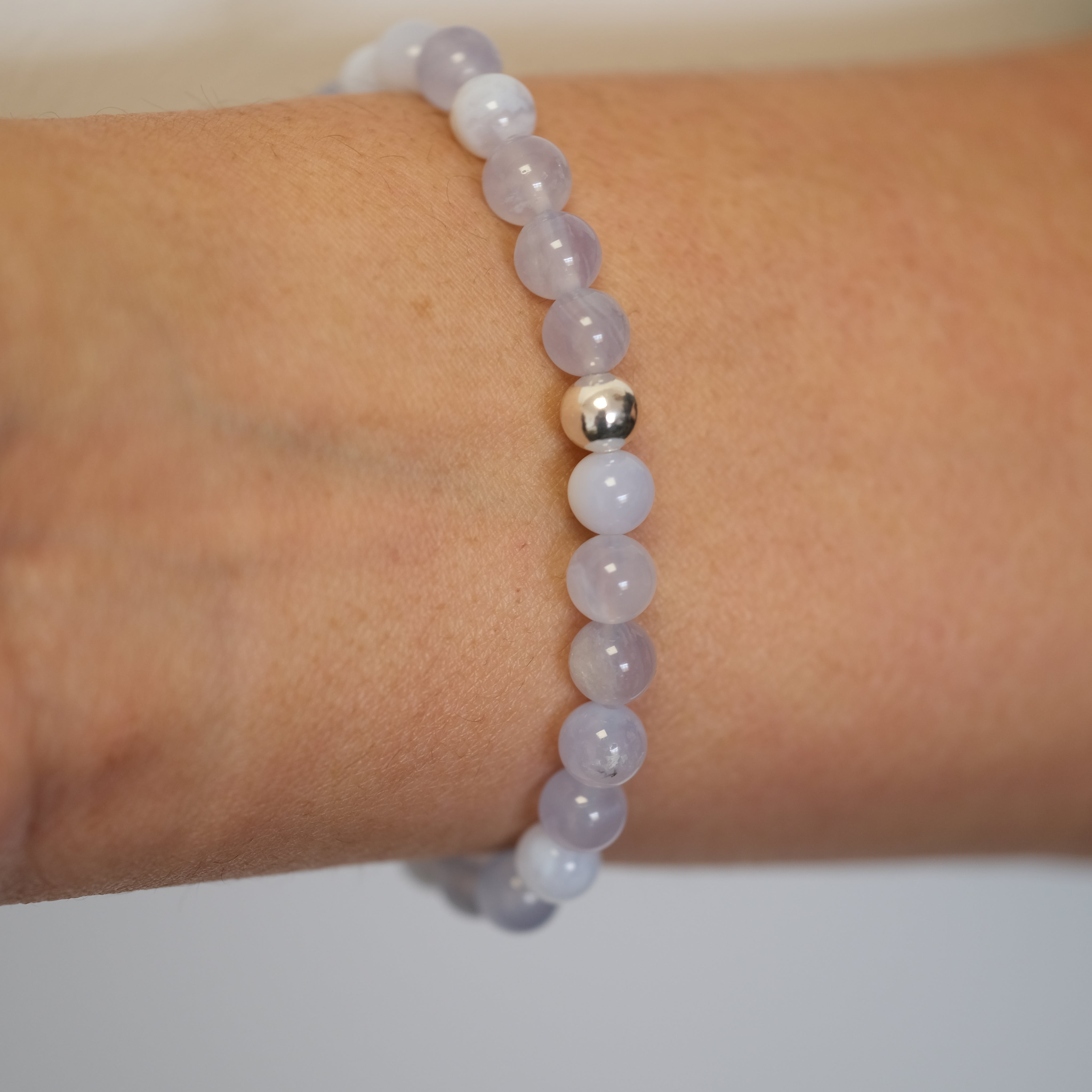 Blue lace agate gemstone bracelet in 6mm beads worn on a model's wrist from the back