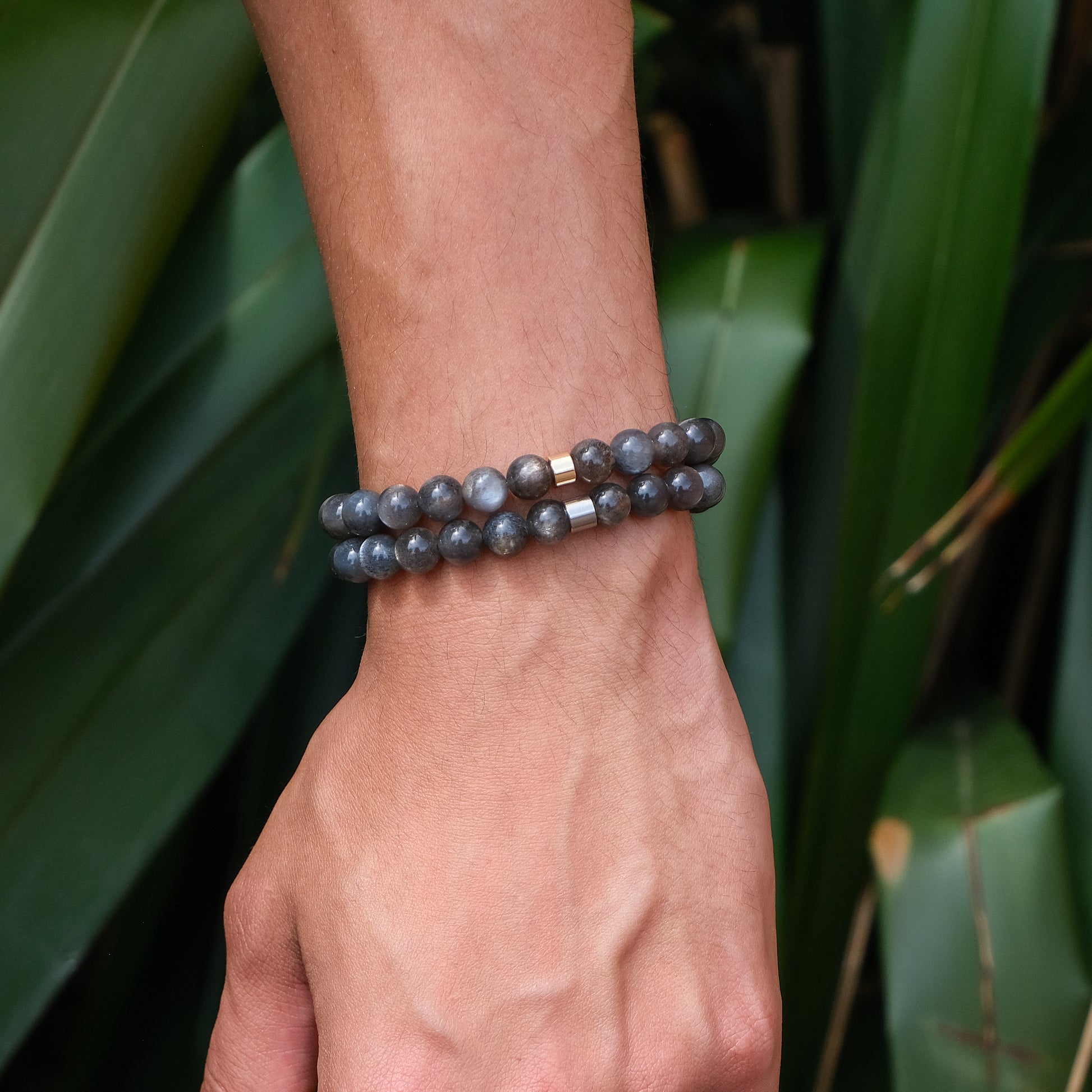 A model wearing two black moonstone gemstone bracelets