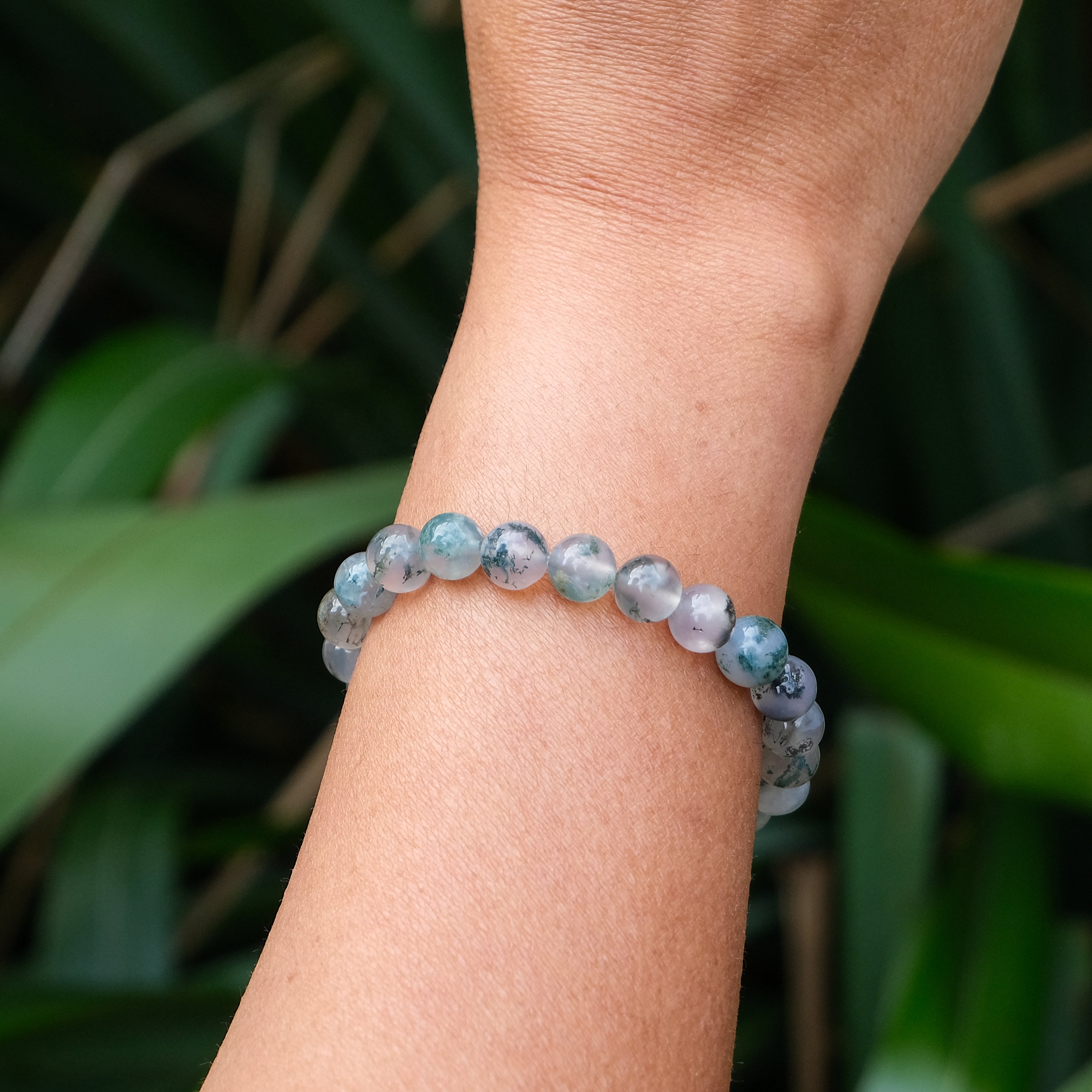 A moss agate gemstone bracelet worn by a model