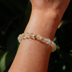 The back of a citrine gemstone bracelet worn on a model's wrist