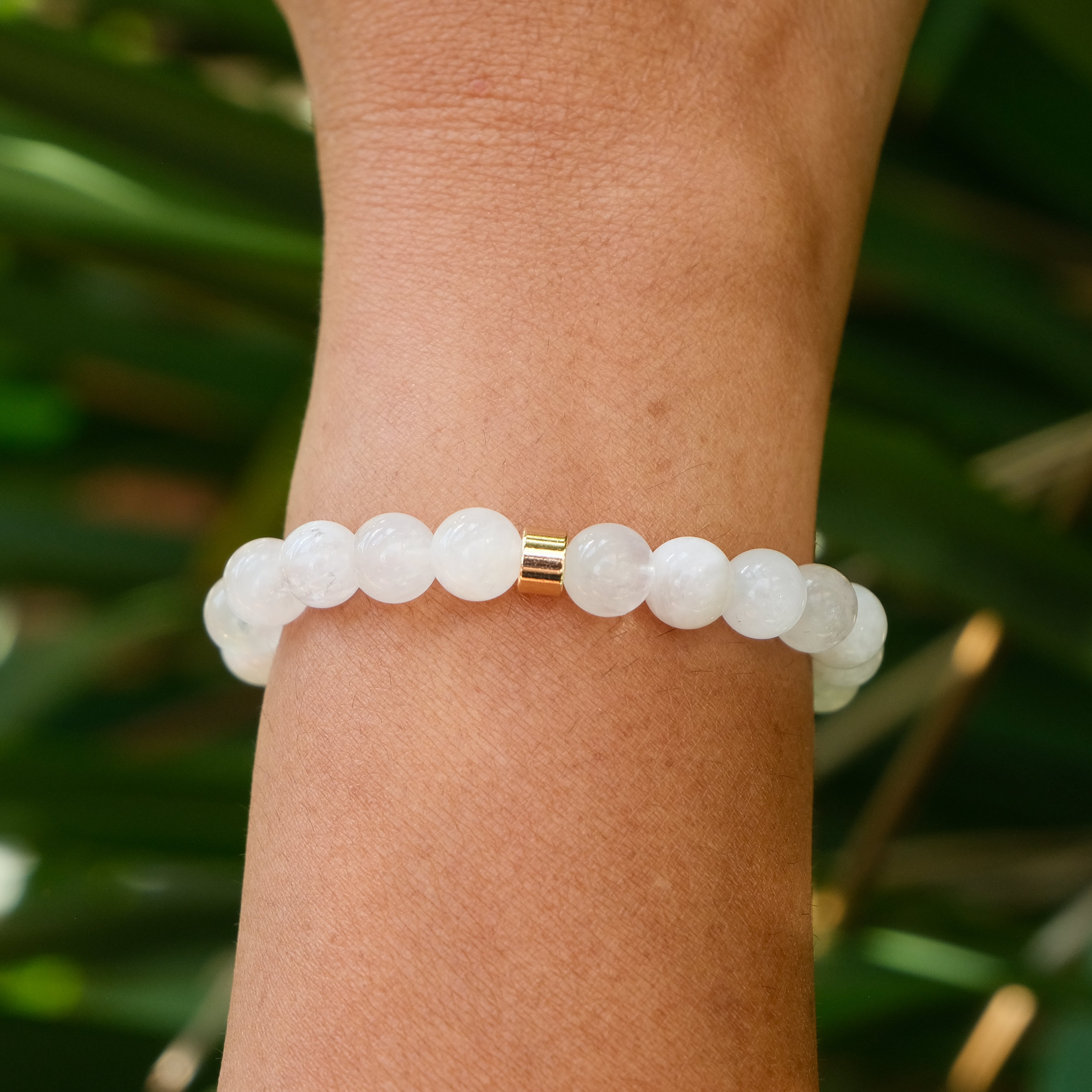 The back of 8mm moonstone gemstone bracelet worn on a model's wrist