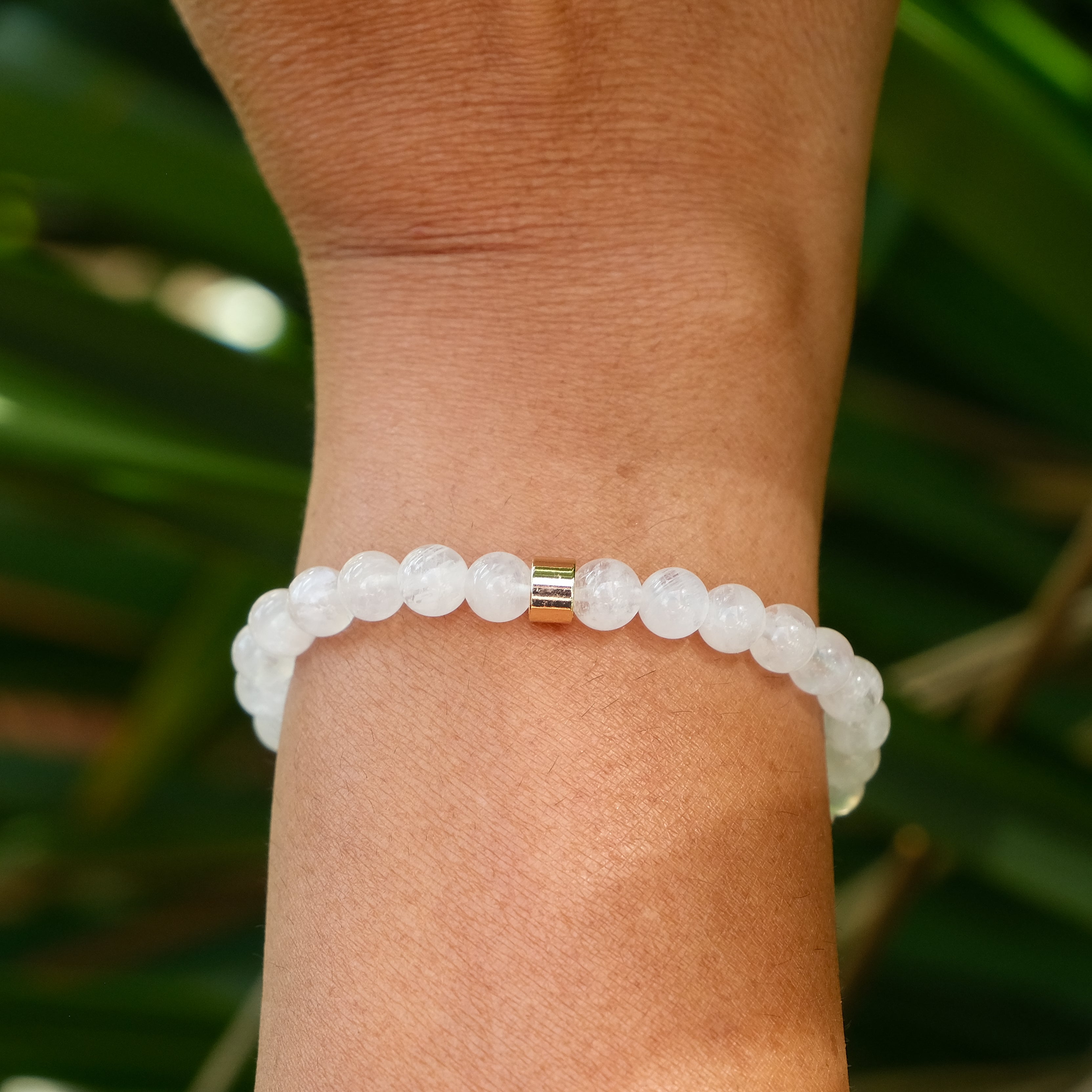 The back of a 6mm moonstone gemstone bracelet on a model's wrist