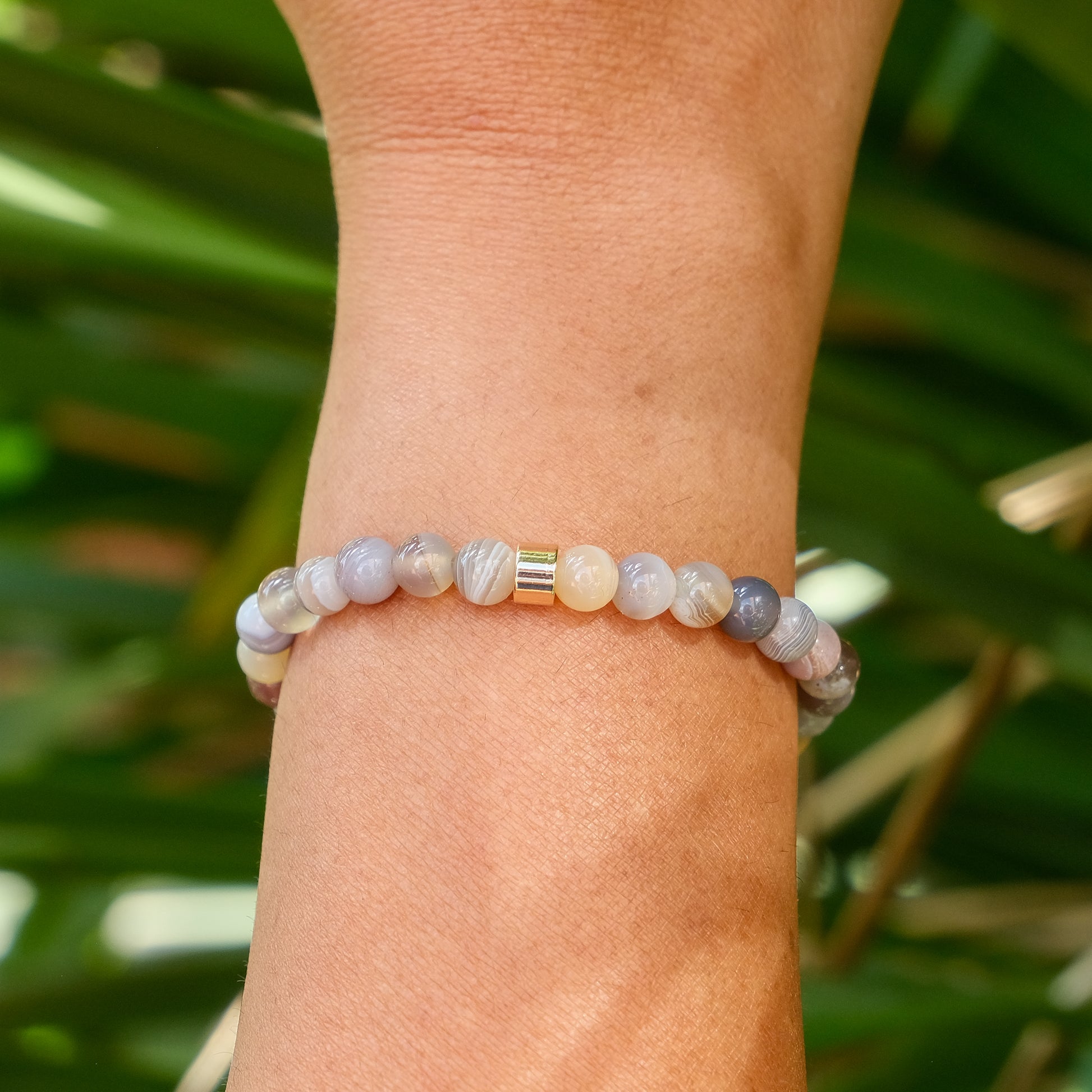 The back of a 6mm botswana agate gemstone bracelet worn on a model's wrist