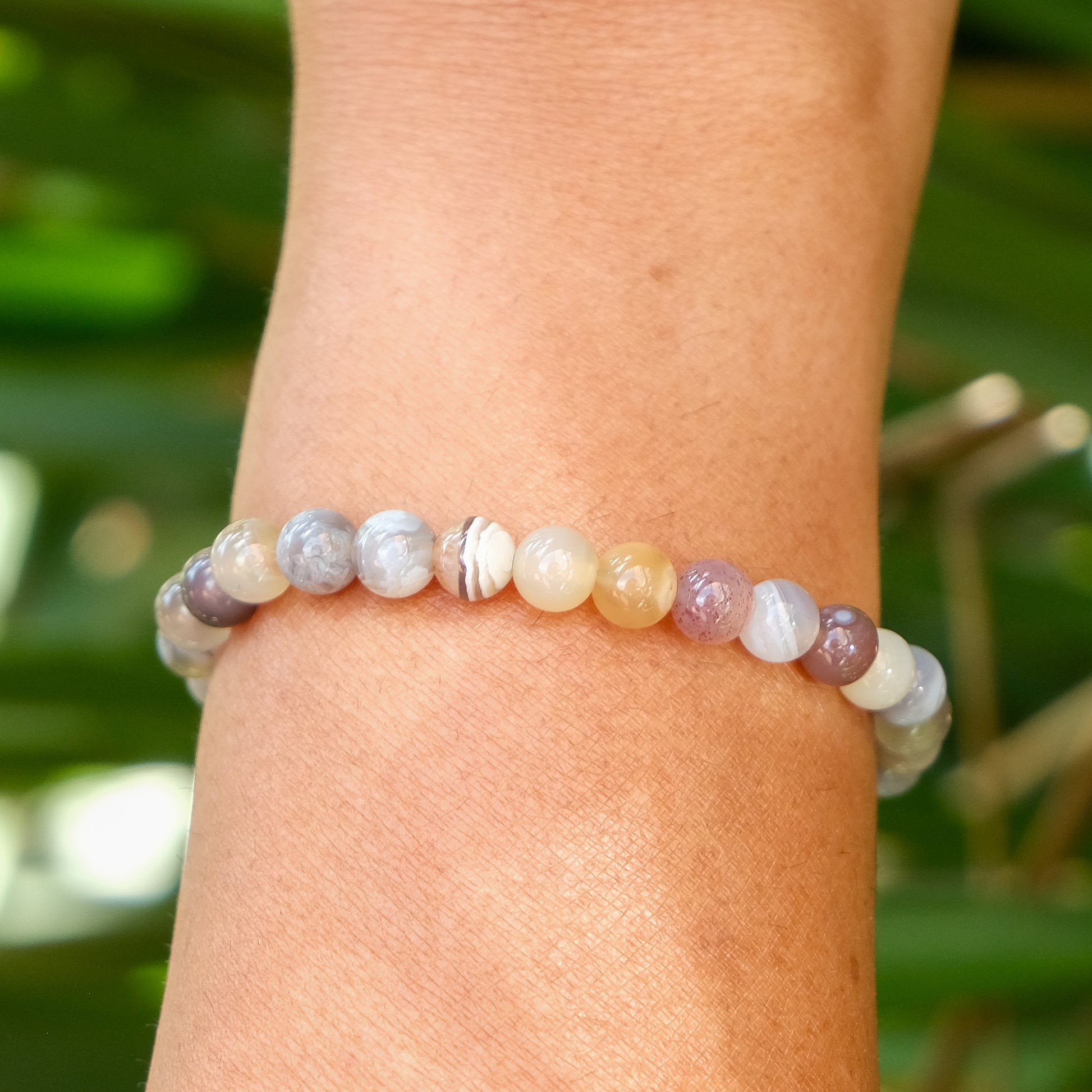 A 6mm botswana agate gemstone bracelet worn on a model's wrist