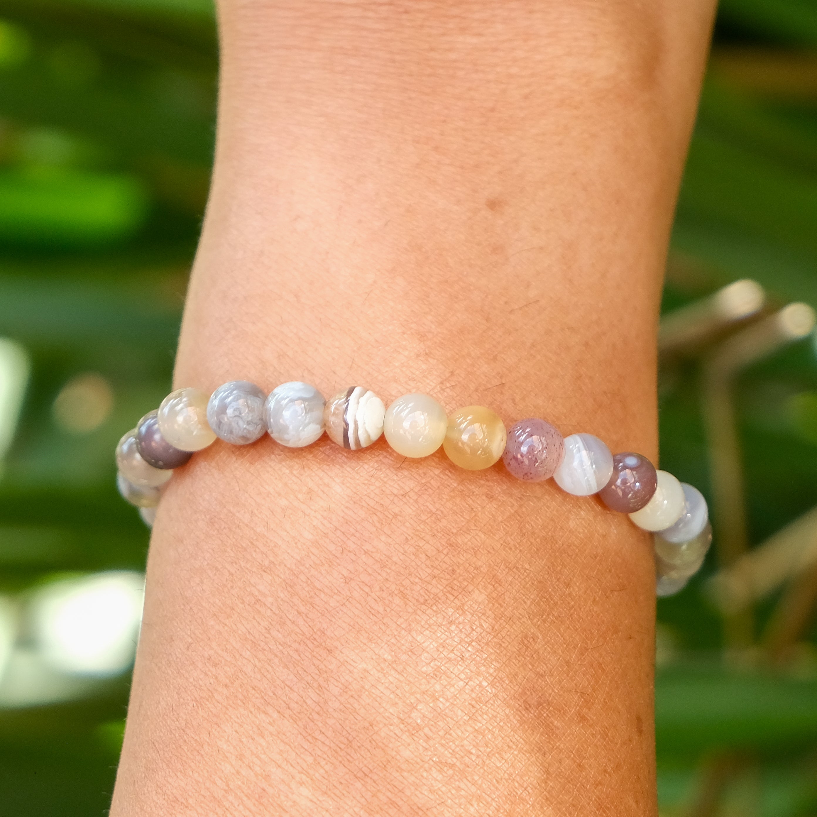A 6mm botswana agate gemstone bracelet worn on a model's wrist