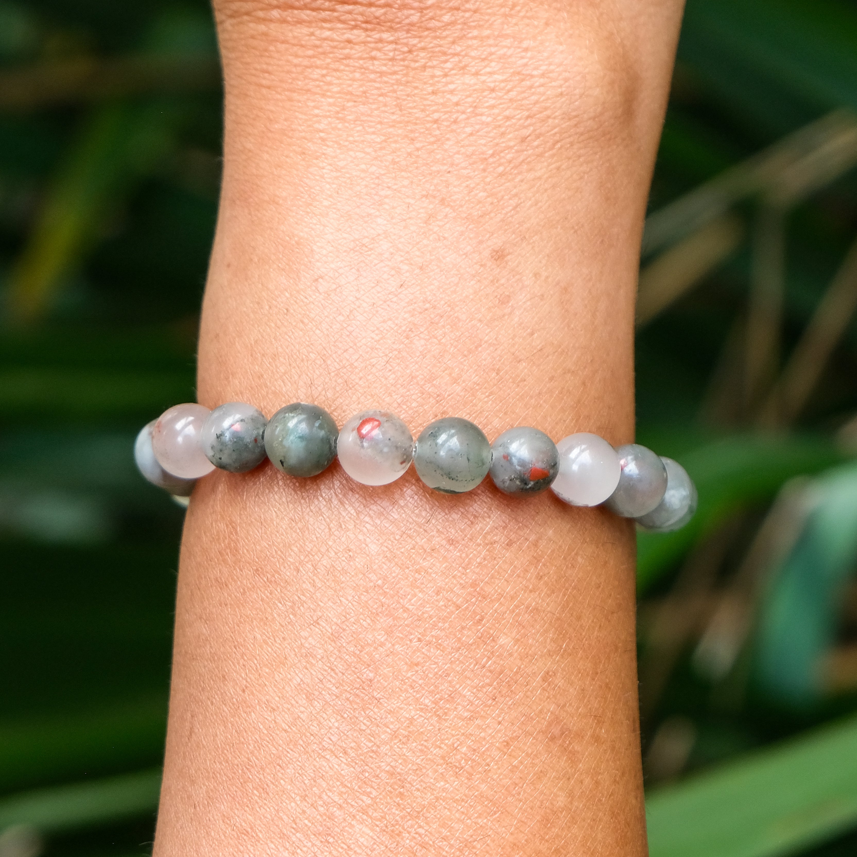 A bloodstone gemstone bracelet worn on a model's wrist
