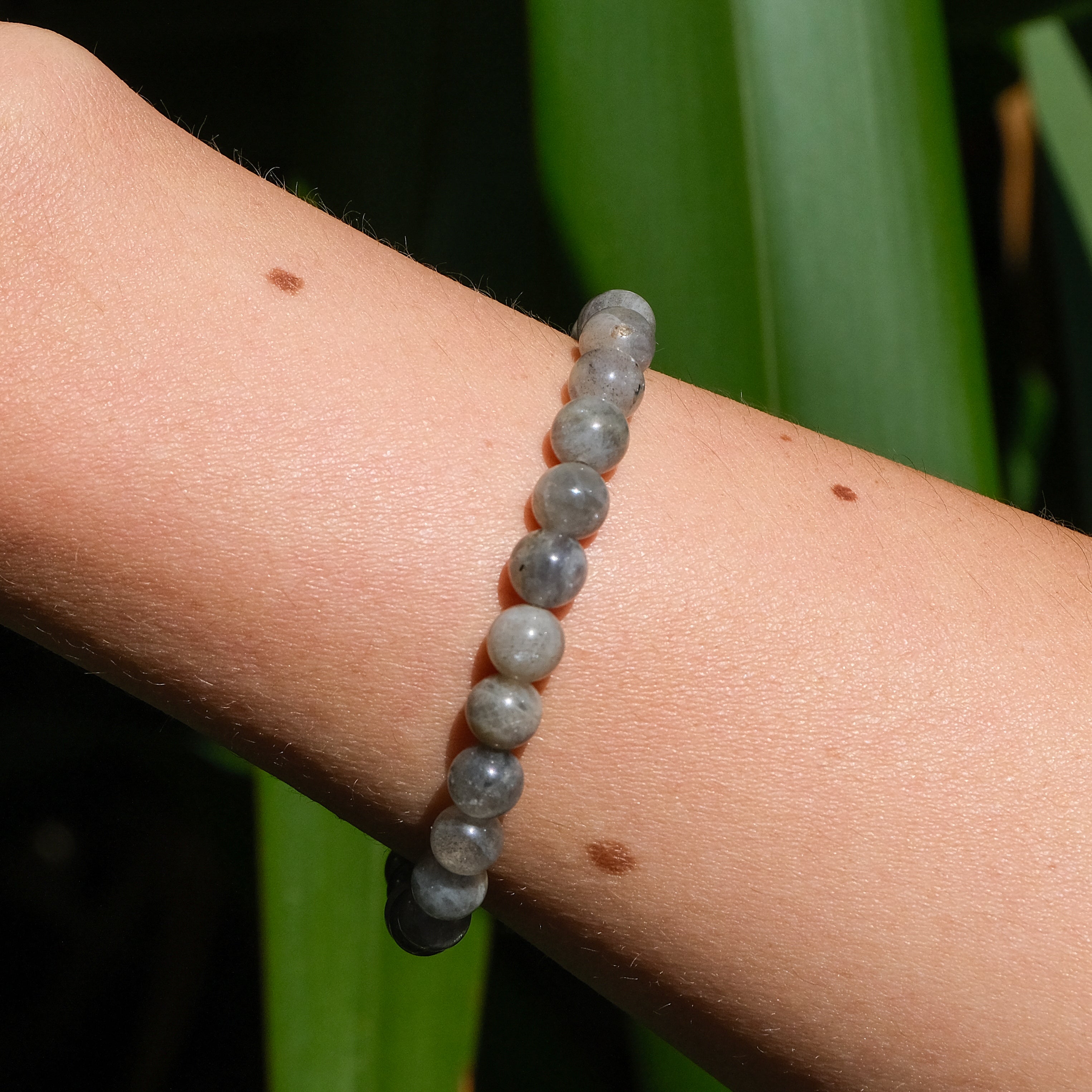 A 6mm labradorite gemstone bracelet worn on a model's wrist