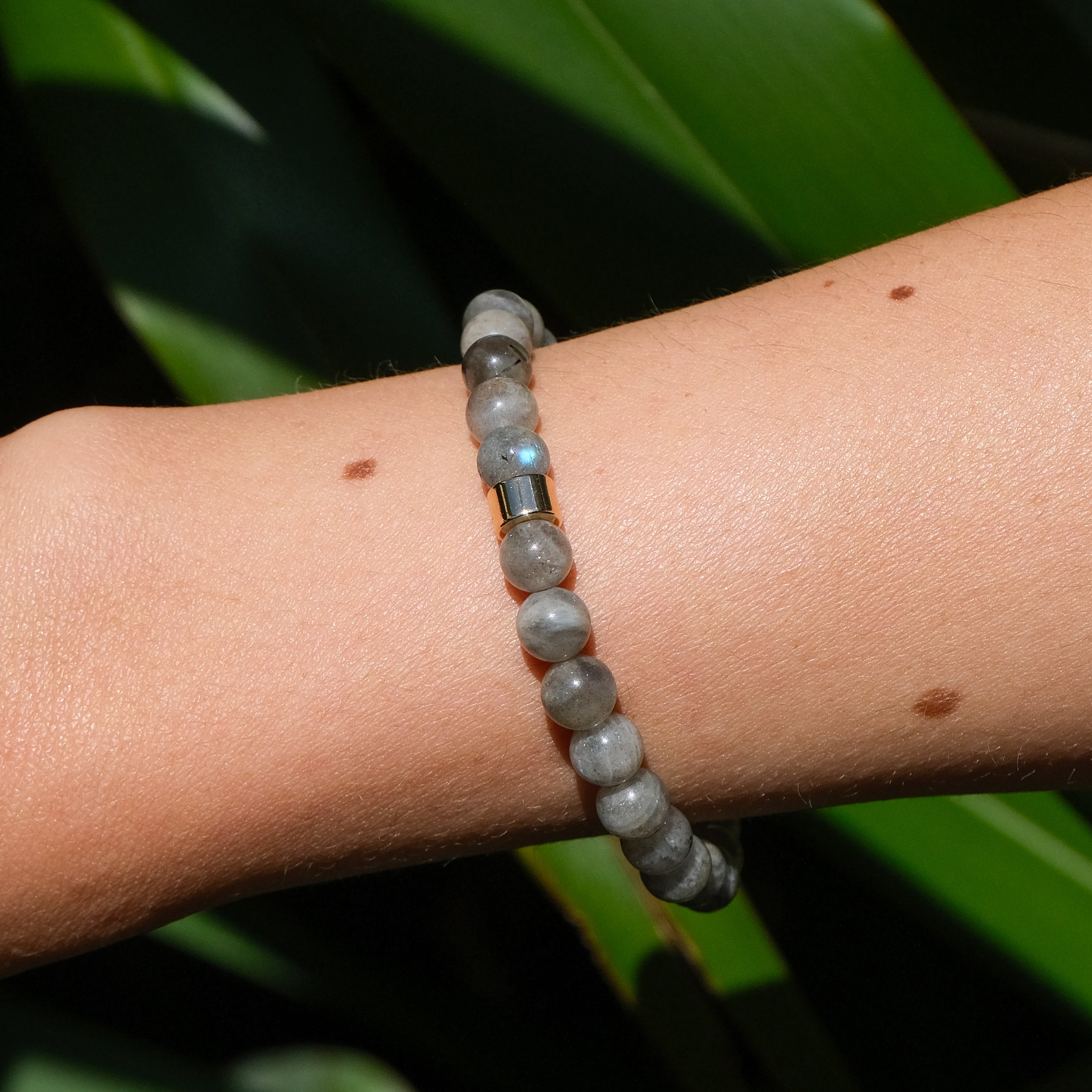A 6mm labradorite gemstone bracelet worn on a model's wrist