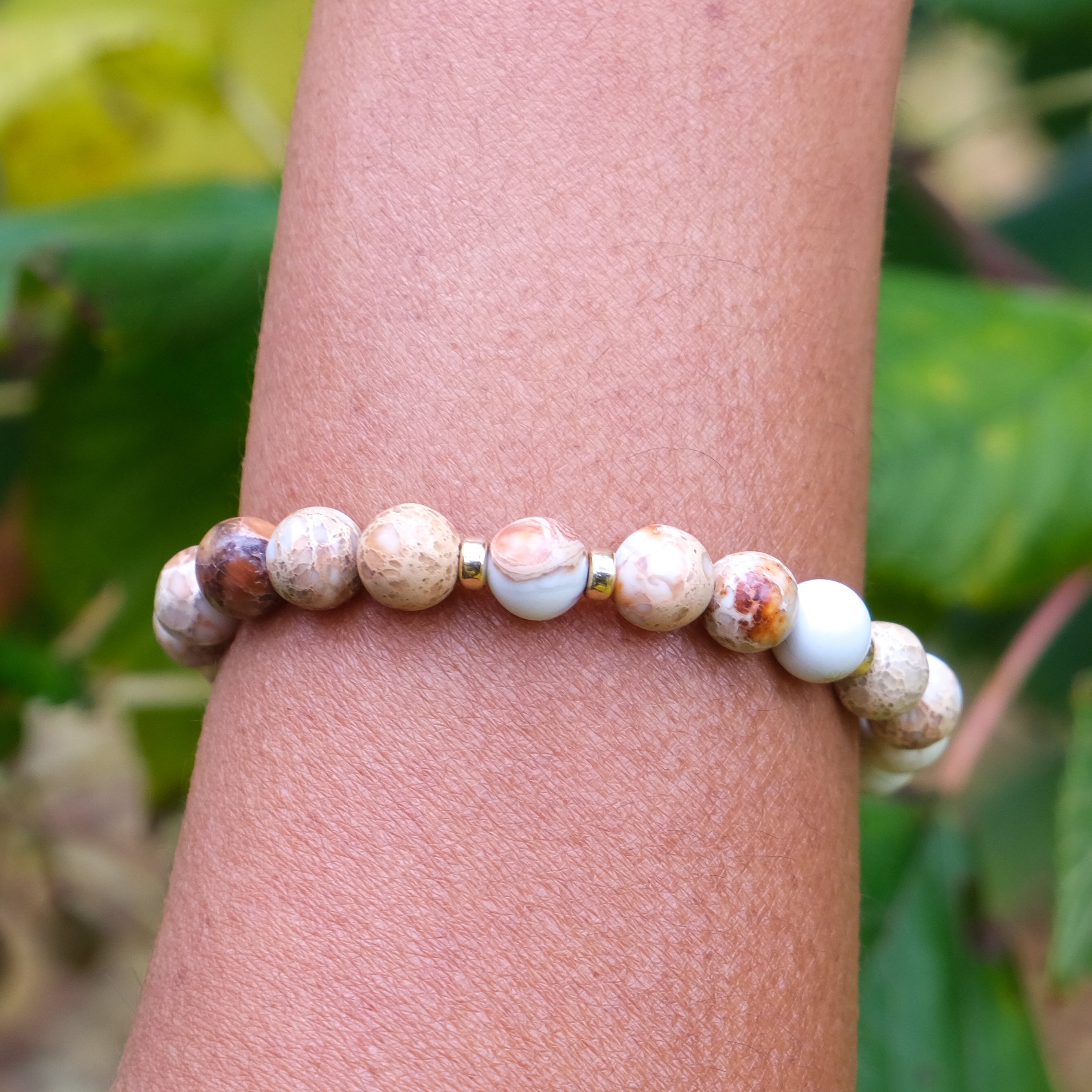 Imperial Jasper gemstone bracelet with gold accessories worn on a model's wrist