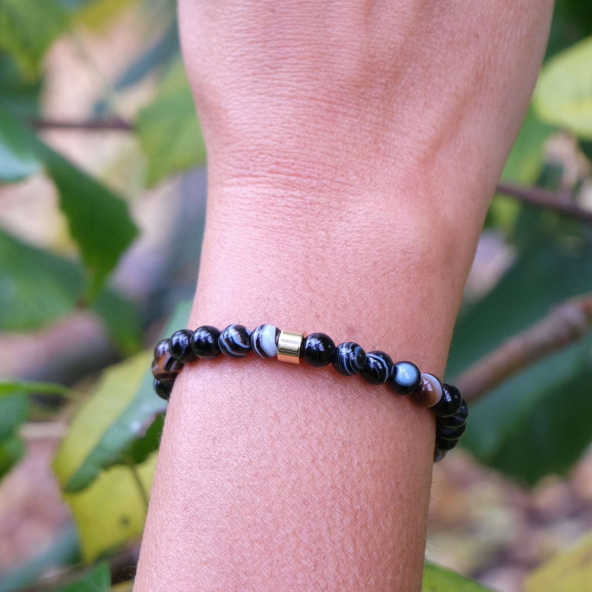 6mm sulemani hakik gemstone bracelet with gold accessories worn on a model's wrist