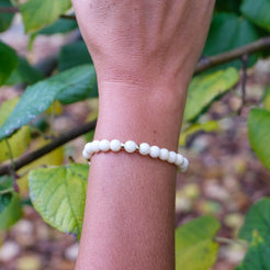 6mm yellow calcite gemstone bracelet with gold accessories worn on a model's wrist