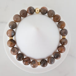 Black moonstone and sunstone gemstone bracelet with gold accessories from above