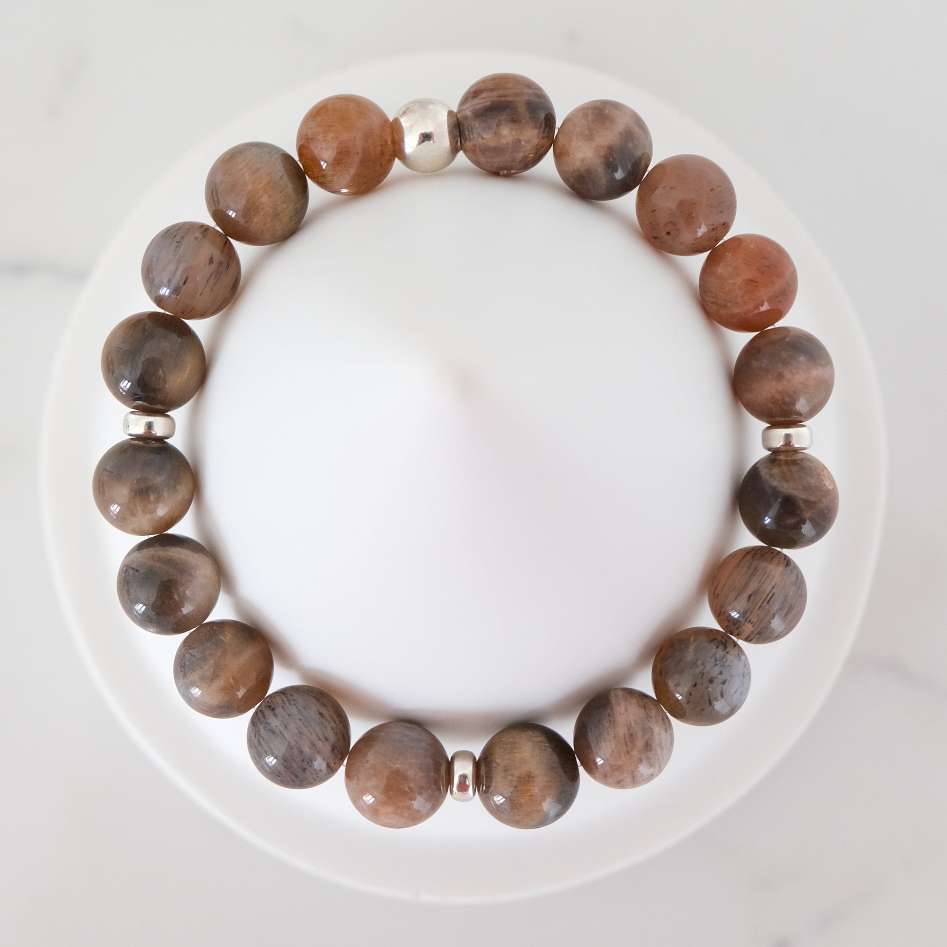 Black moonstone and sunstone gemstone bracelet with silver accessories from above