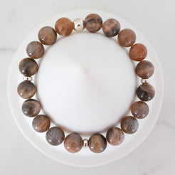 Black moonstone and sunstone gemstone bracelet with silver accessories from above