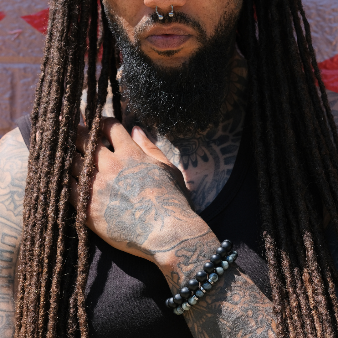 A model wearing an eagle eye gemstone bracelet with stainless steel accessories