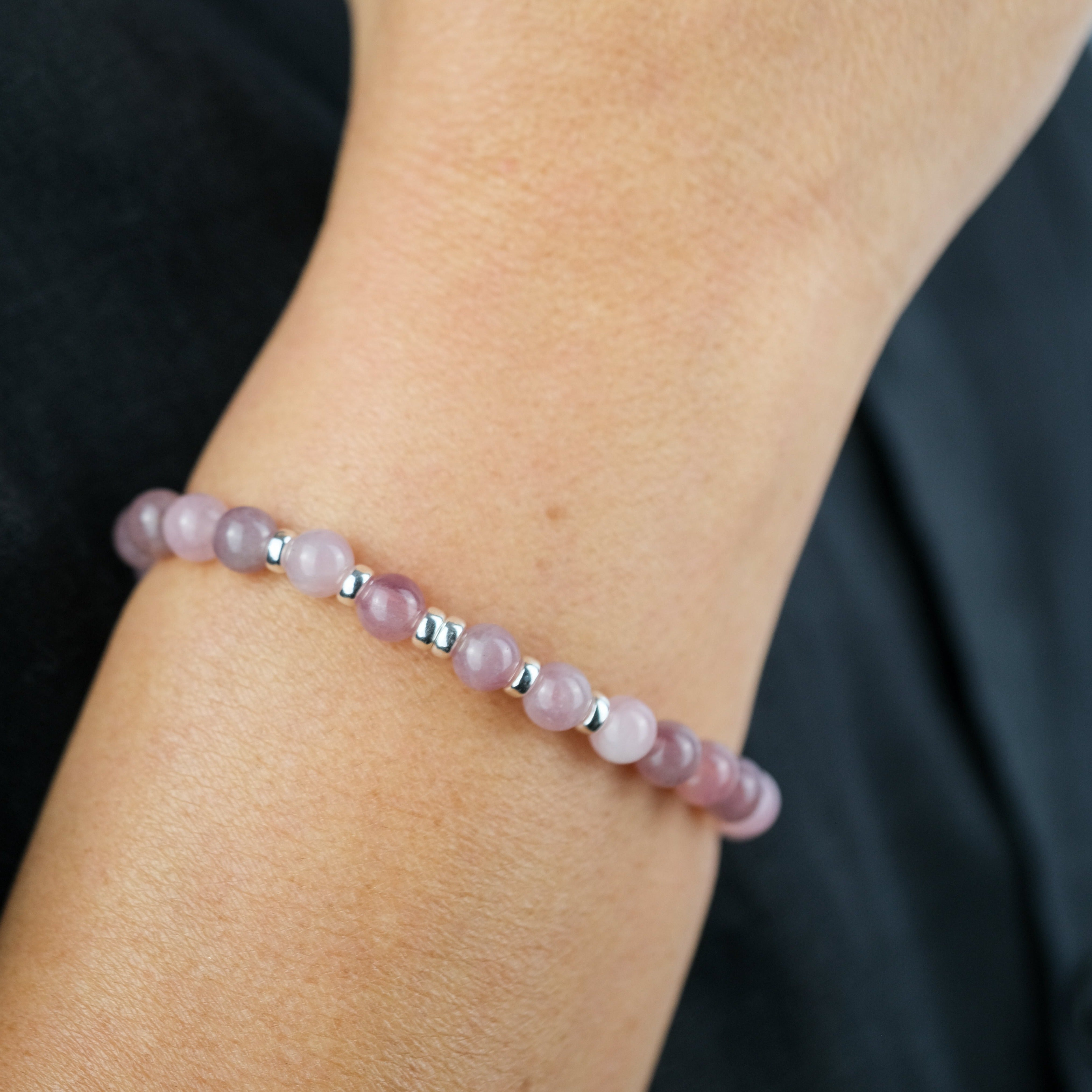 A model wearing a lavender rose quartz 6mm gemstone bracelet with 925 sterling silver accessories