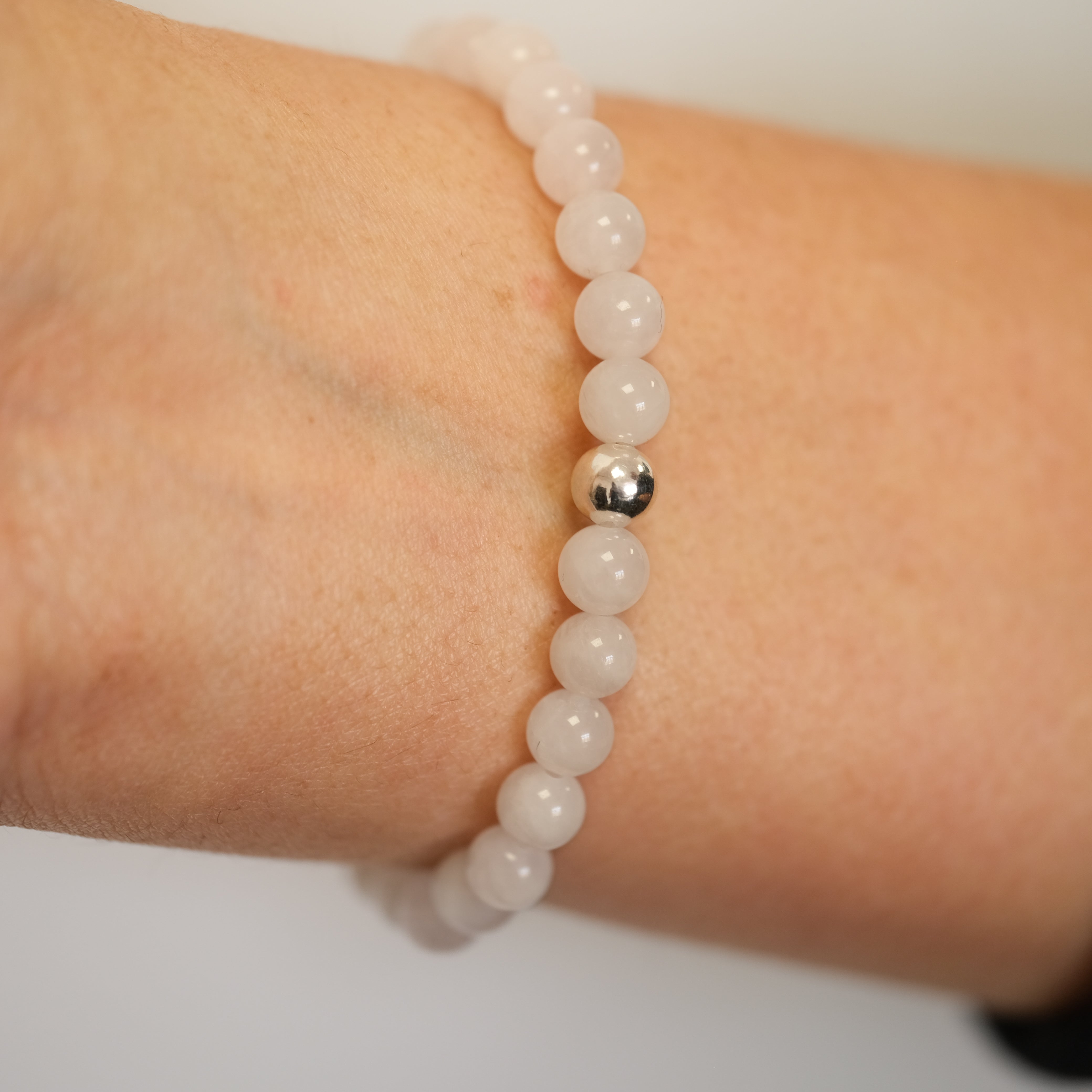 Rose Quartz gemstone bracelet worn on a model's wrist from behind