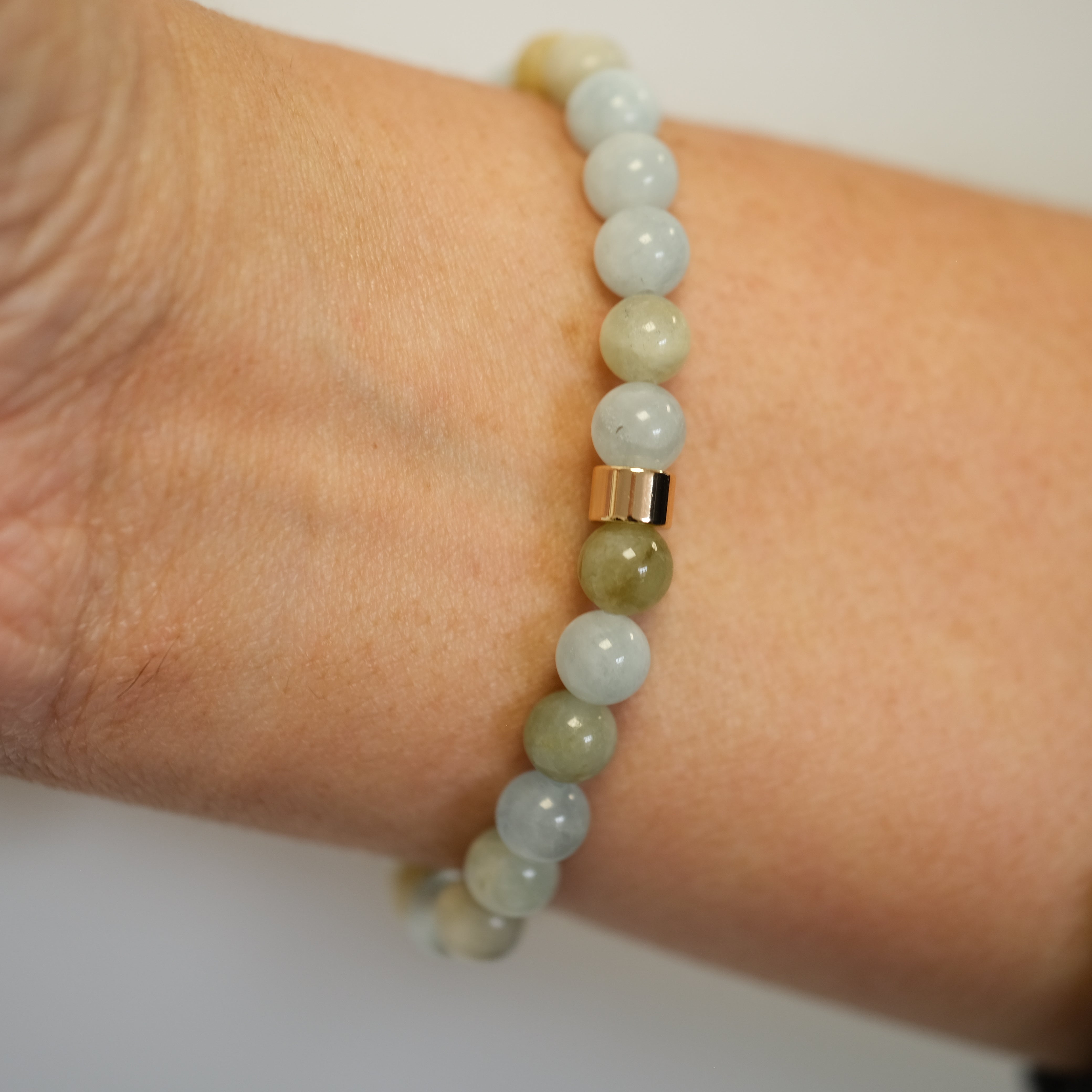 Aquamarine gemstone bracelet in 6mm beads worn on a model's wrist from behind