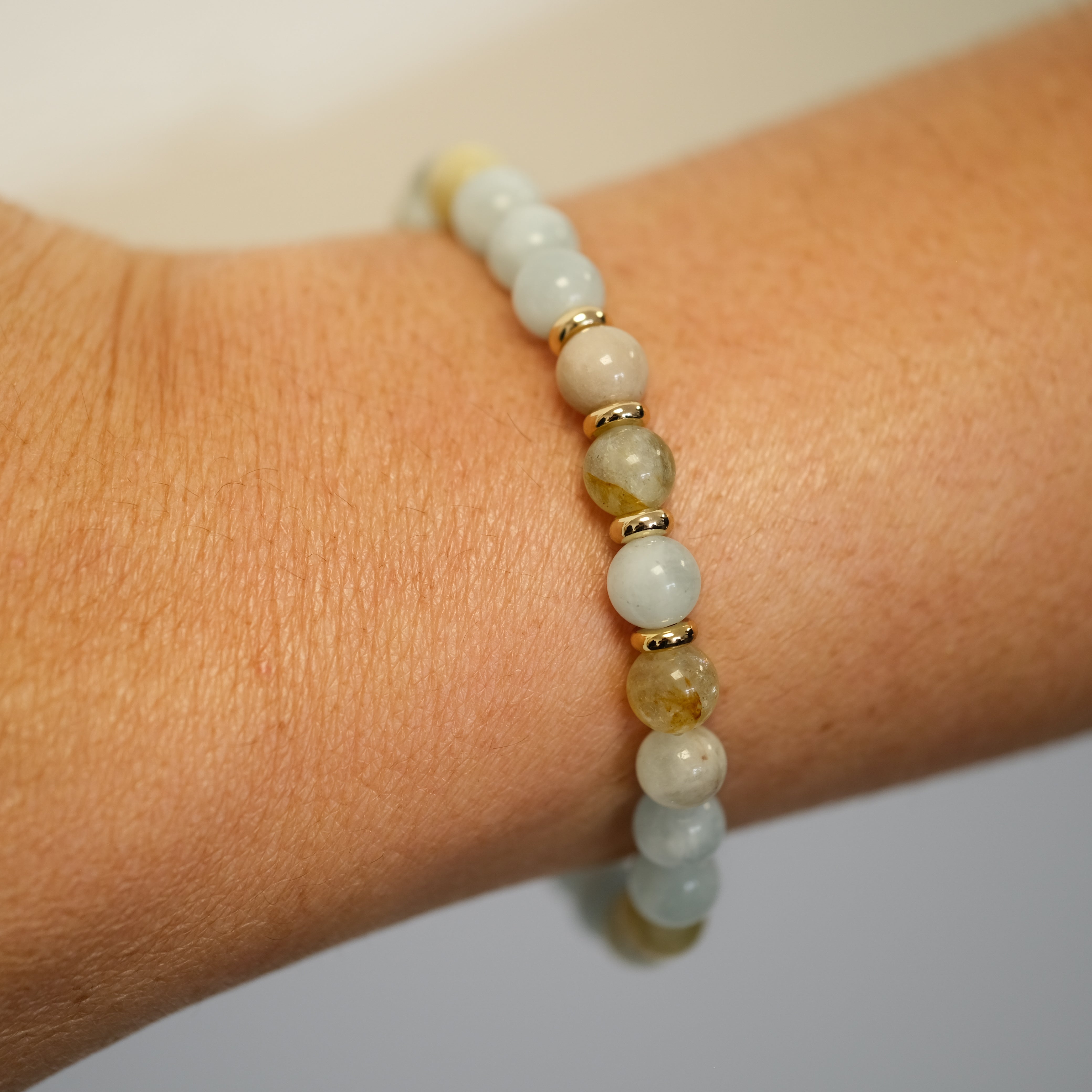 Aquamarine gemstone bracelet in 6mm beads worn on a model's wrist