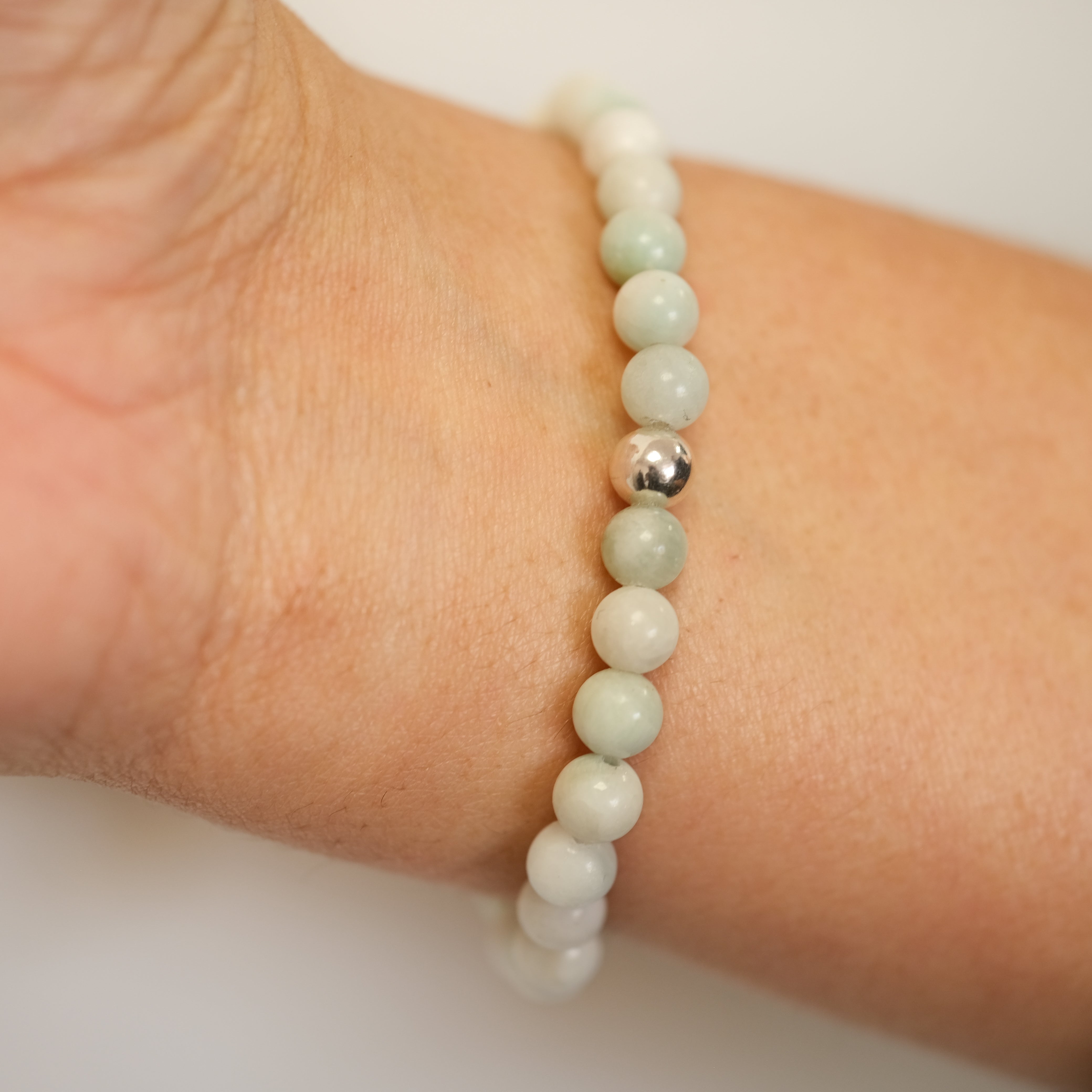 A Larimar gemstone bracelet worn on a model's wrist from behind