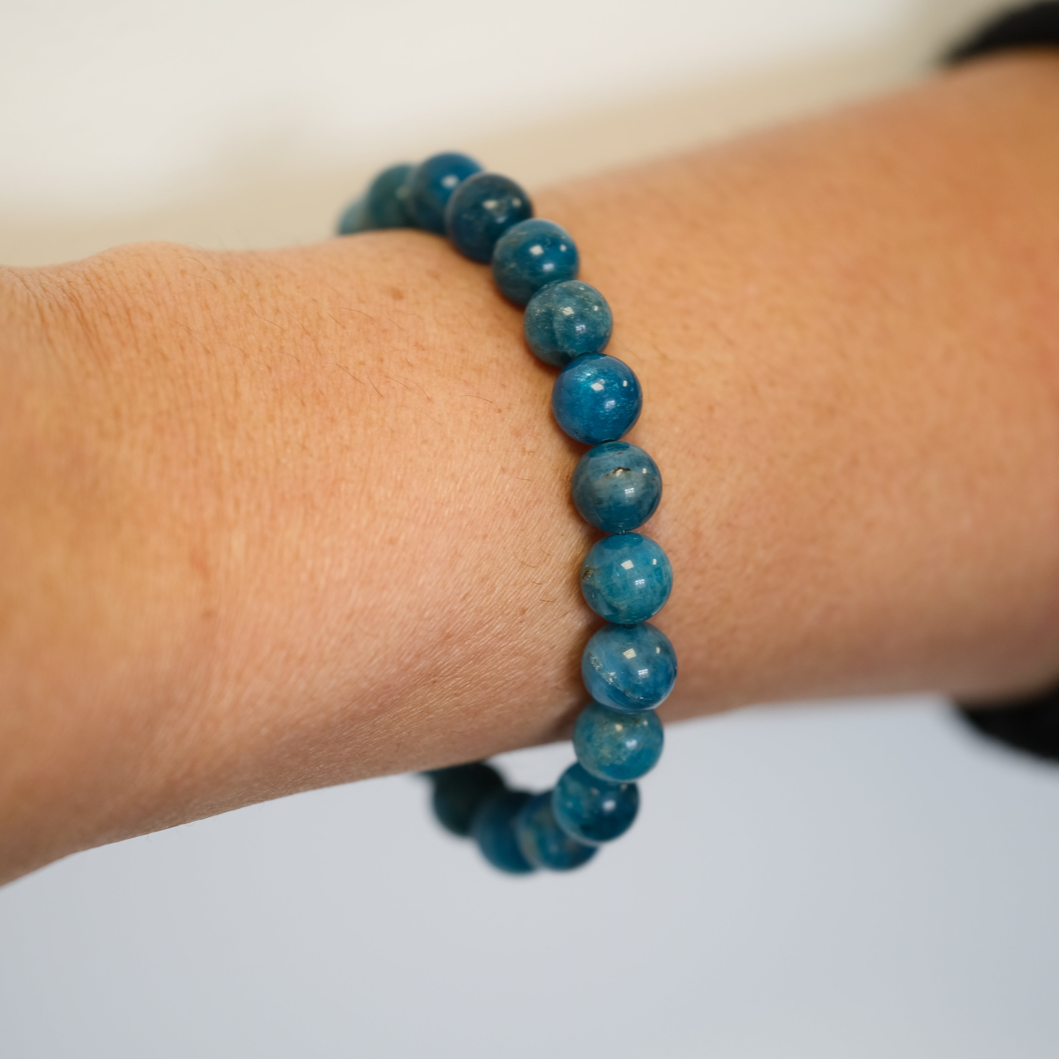 Apatite gemstone bracelet worn on a model's wrist