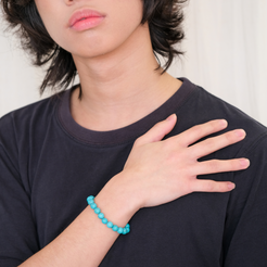 A male model wearing an 8mm turquoise gemstone bracelet
