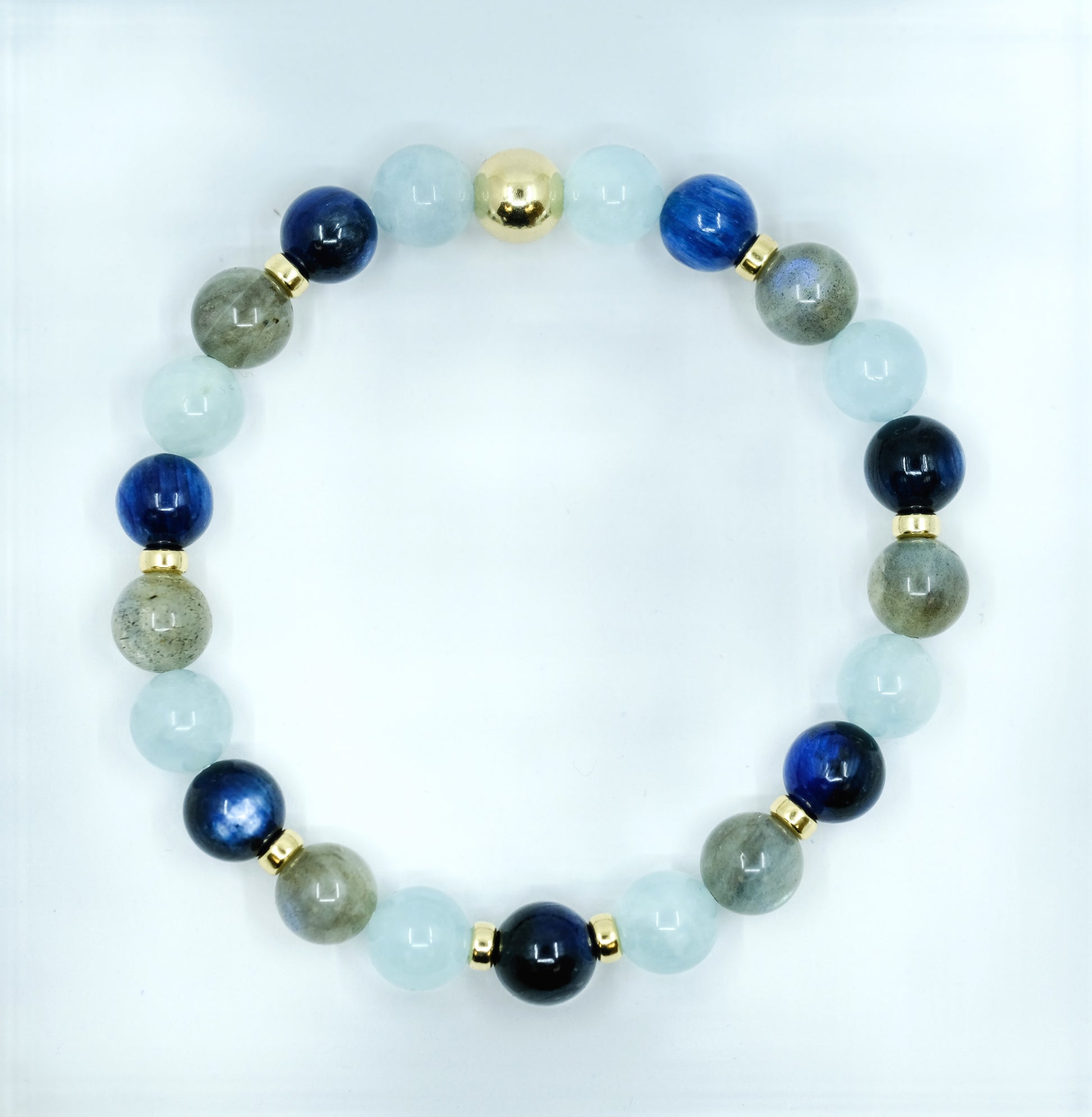 A Kyanite, Aquamarine and Labradorite gemstone bracelet with gold accessories from above