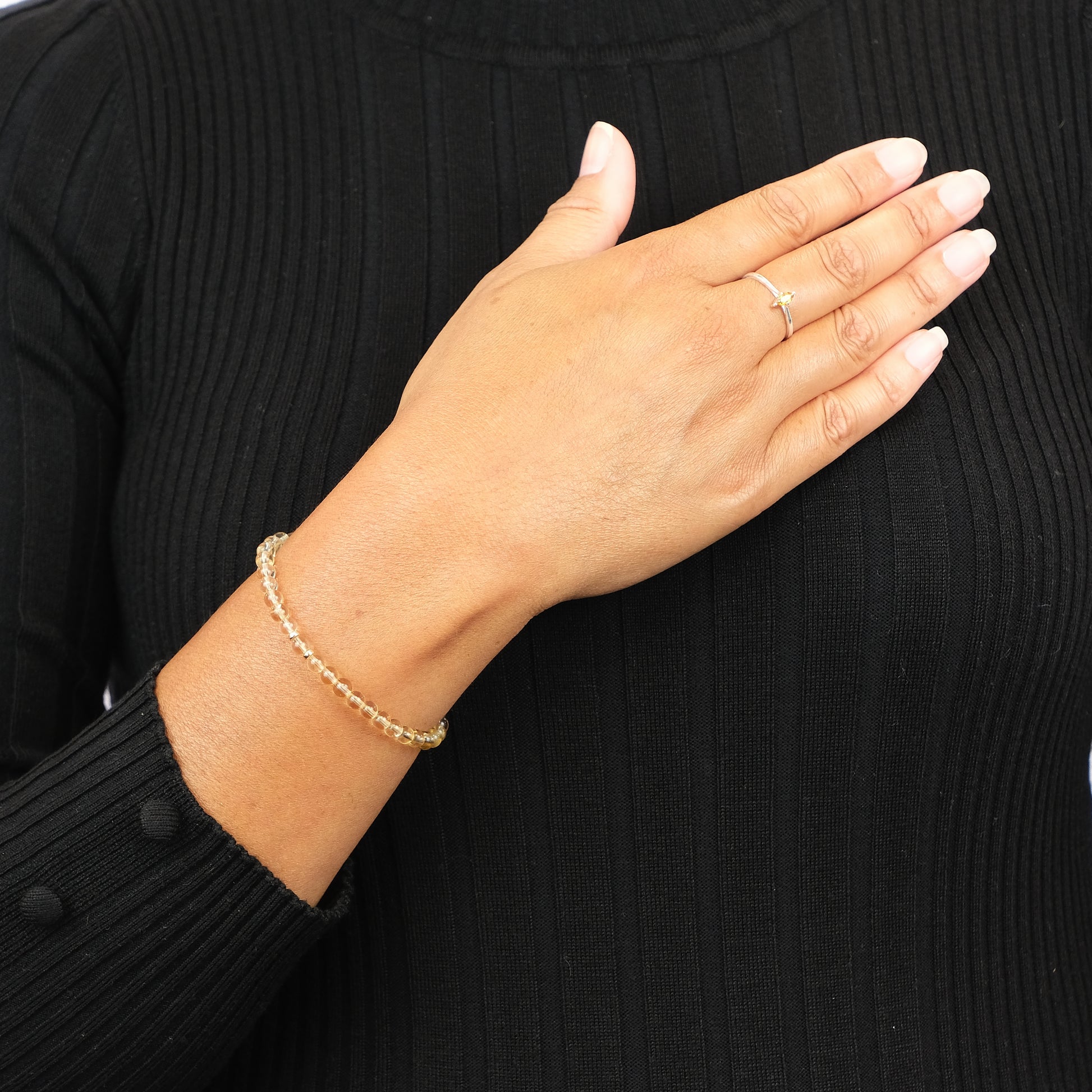 A model wearing 4mm Citrine energy gemstone bracelet with gold accessories